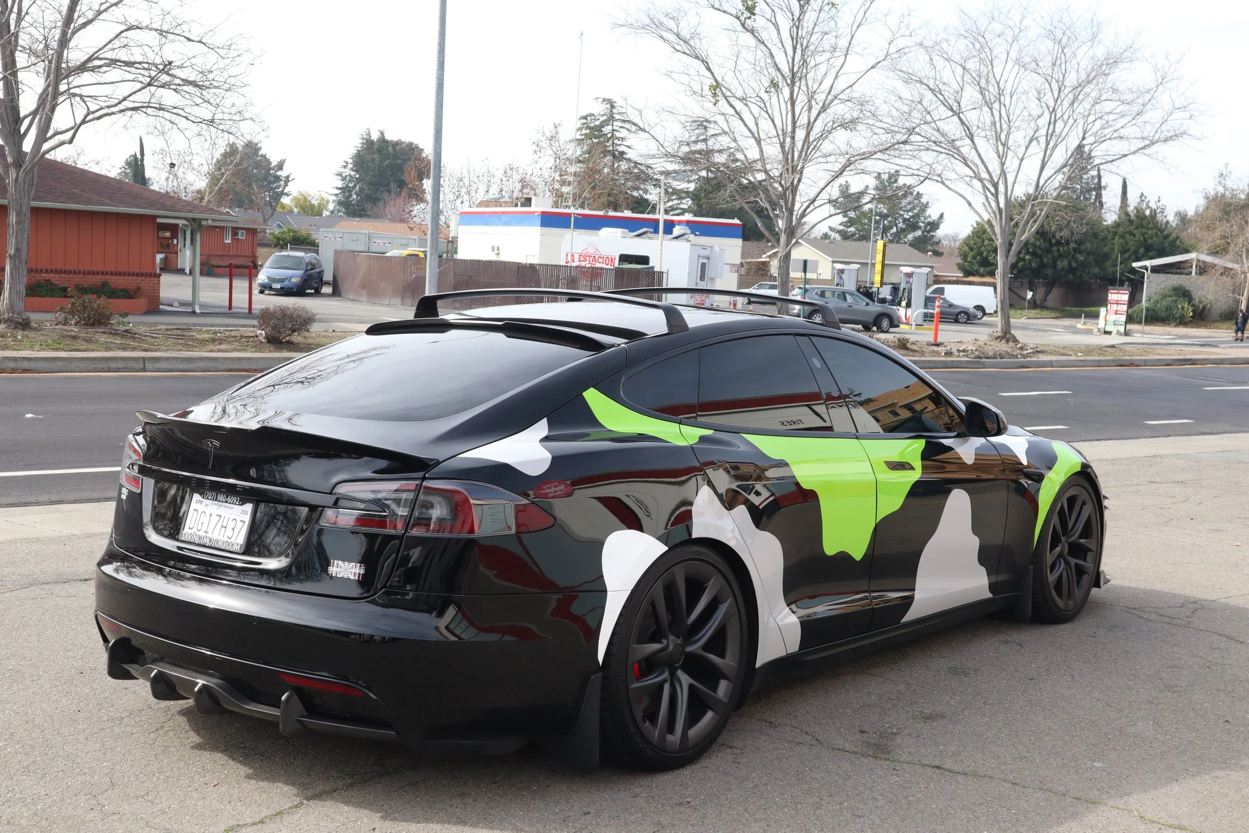 Tesla with custom camouflage vinyl wrap and tinted windows & Paint Protection Film clear gloss to protect against rock chips