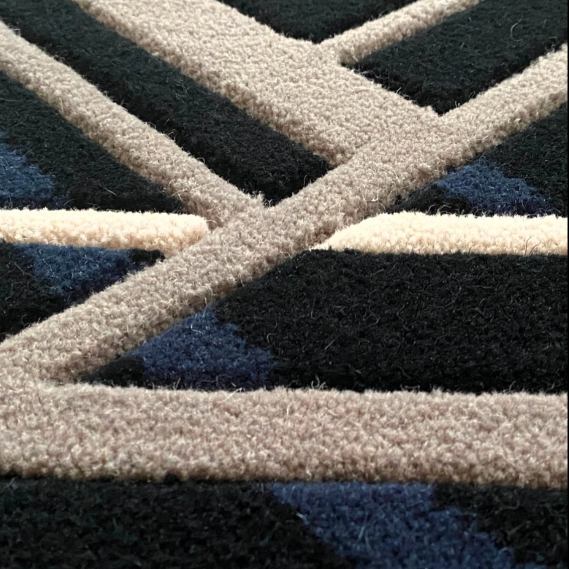 Hand carved Axminster details on geometric carpet design.