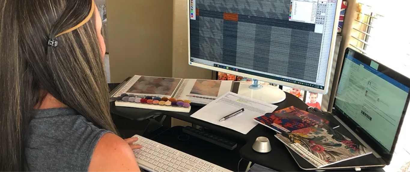 Axminster carpet designer working on computer.