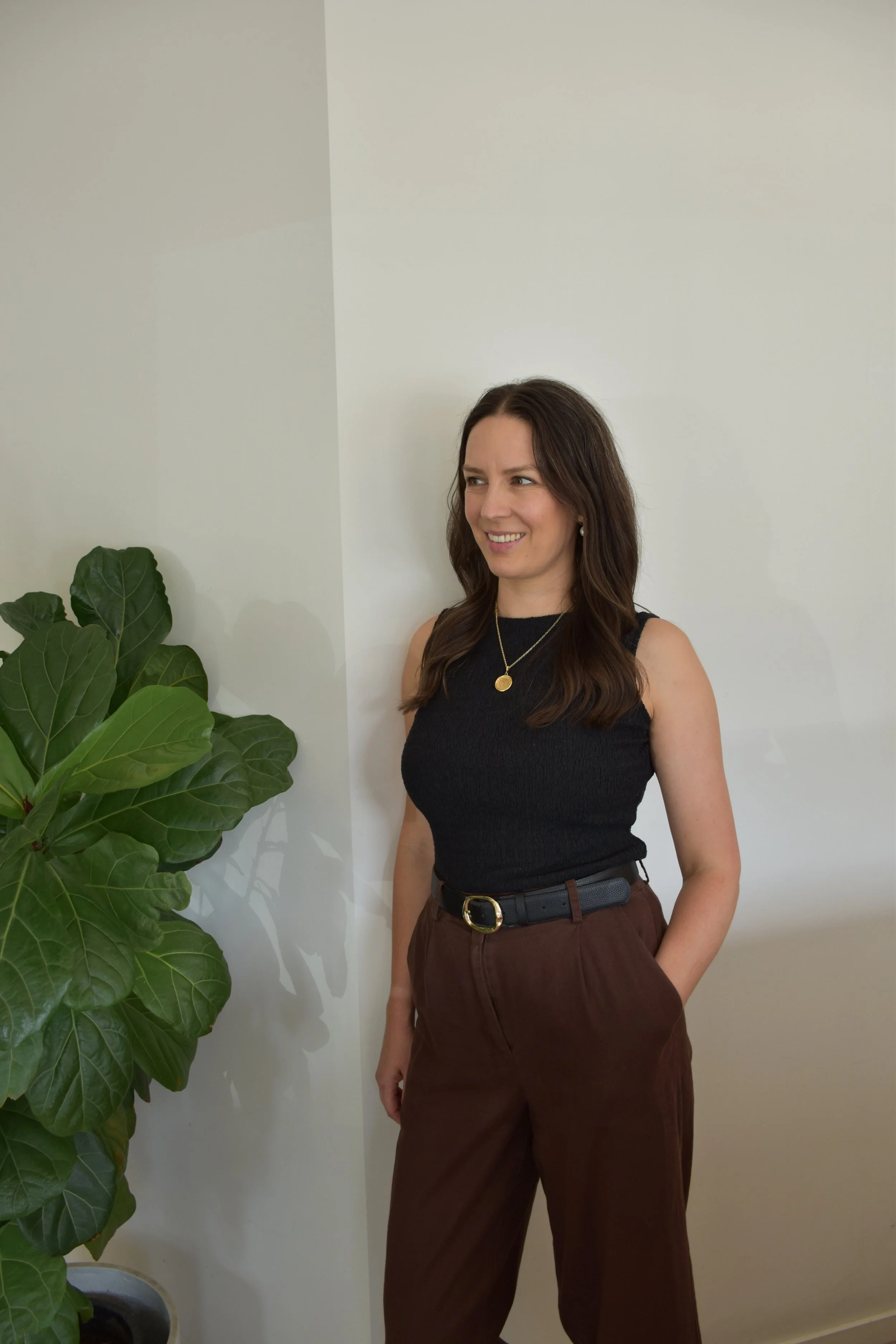 A fertility acupuncture practitioner leaning up against a wall working on complex fertility issues for clients in Melbourne
