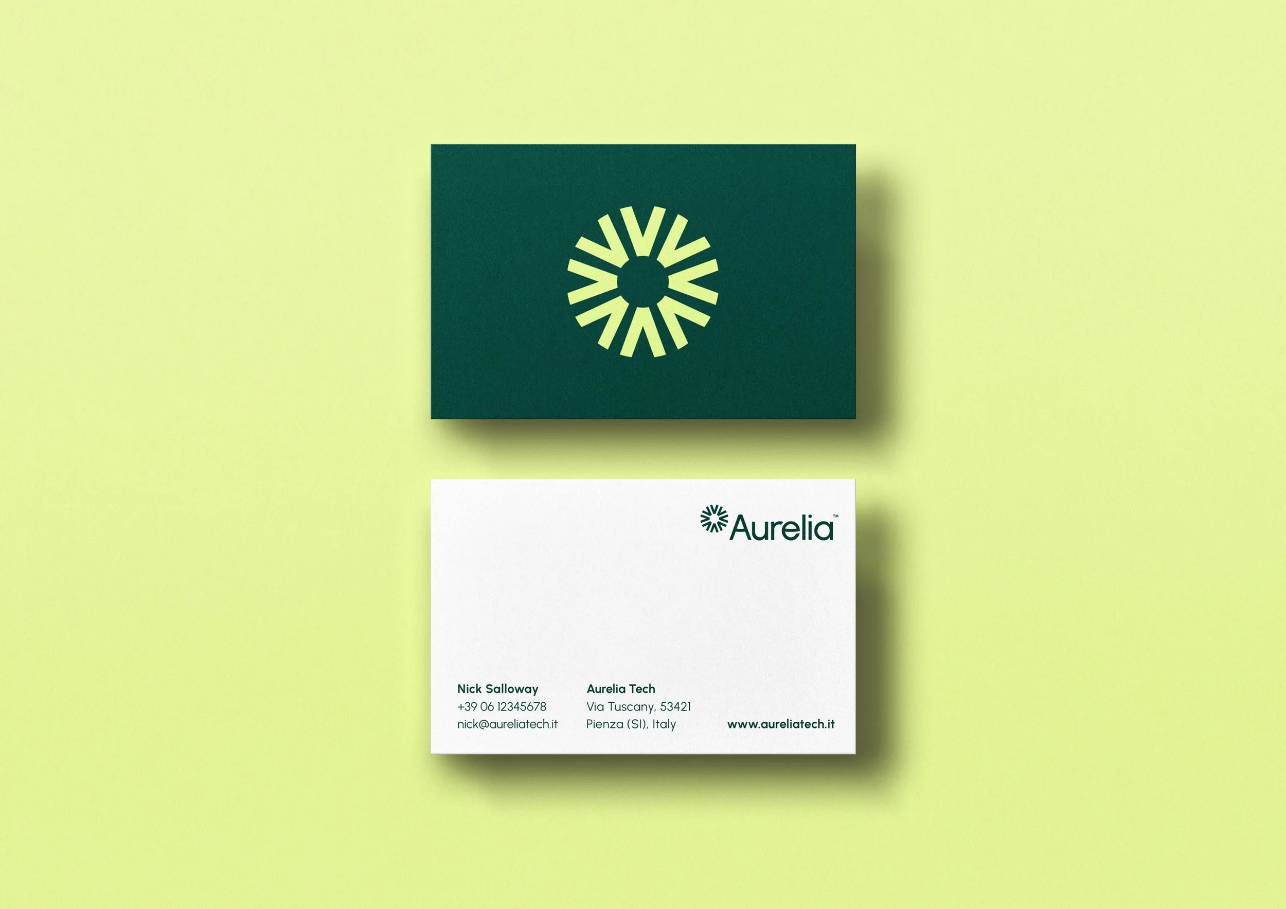 A business card with a green logo featuring a circular, radiating design, placed on a light green background. The card includes contact information for Nick Salloway at Aurelia Tech, with a website www.aureliatech.it.