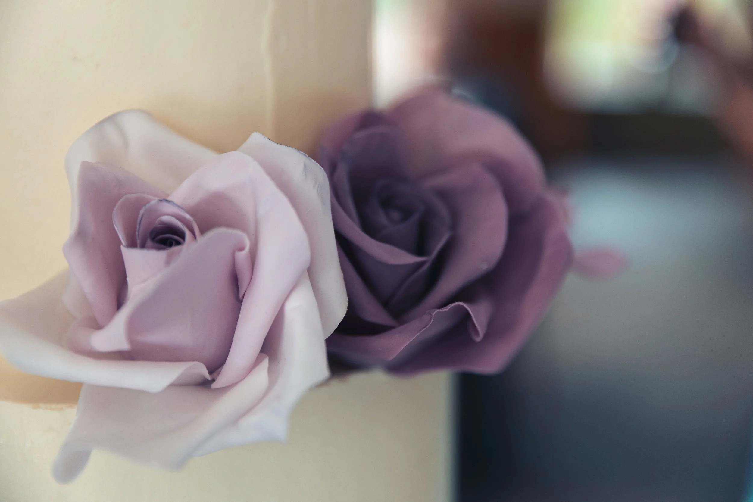 Close up of purple sugar roses on tiered cake