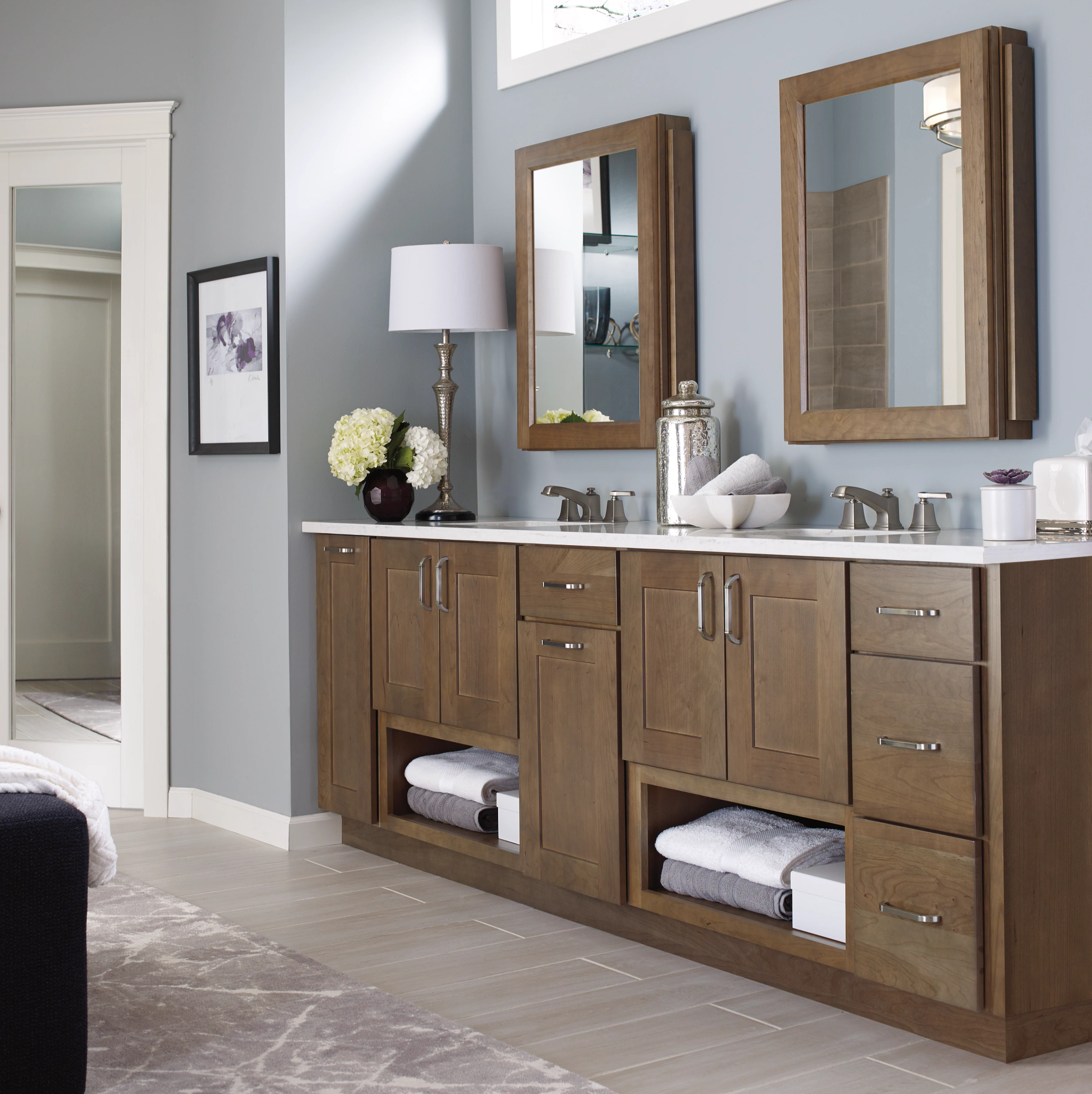 A modern bathroom has a double vanity and matching cabinets so everyone has their own space.