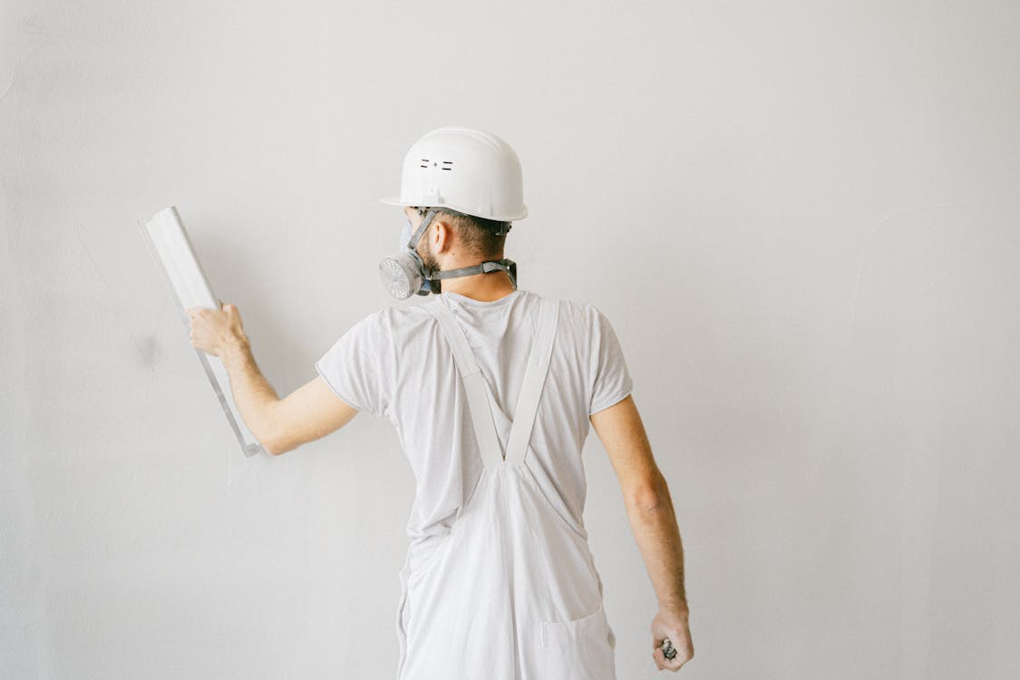 A professional is applying plaster to a wall.