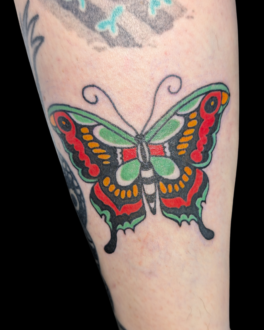 Tattoo of a skull wearing a samurai helmet, with a sword beneath it, on a person's forearm.