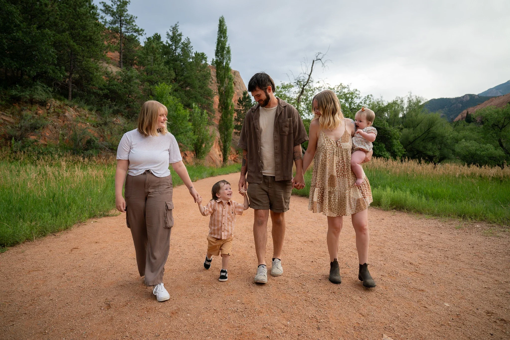 A beautiful family portrait walking the trail together at Red Rock Canyon Open Space in Colorado Springs. Relaxed, natural and fun Summer family photoshoot captured by Denver photographer Ryan Kost