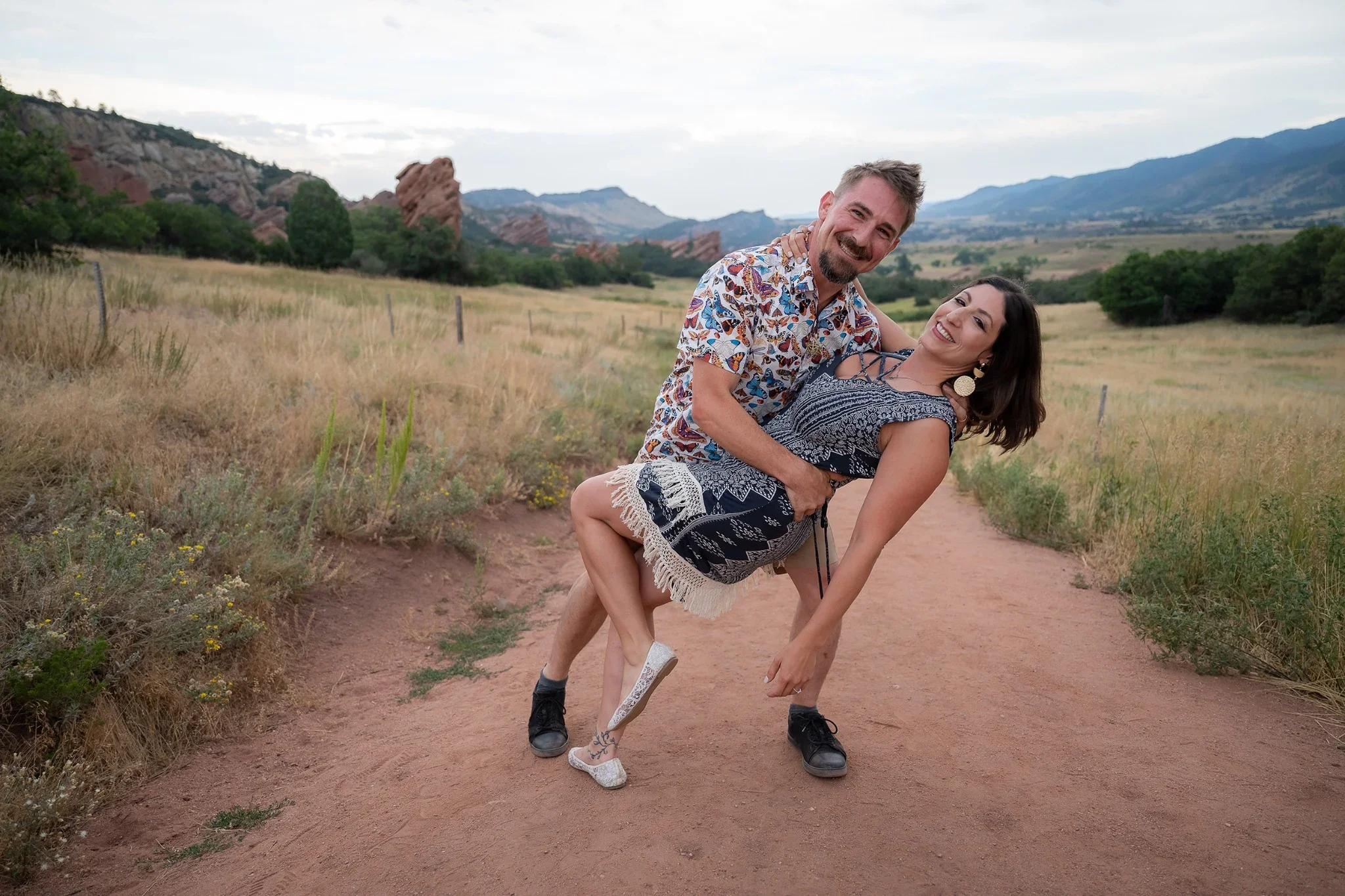 A fun, family couple portrait dancing together during a golden hour summer family photoshoot at South Valley Park in Littleton, Colorado captured by Ryan Kost Photography