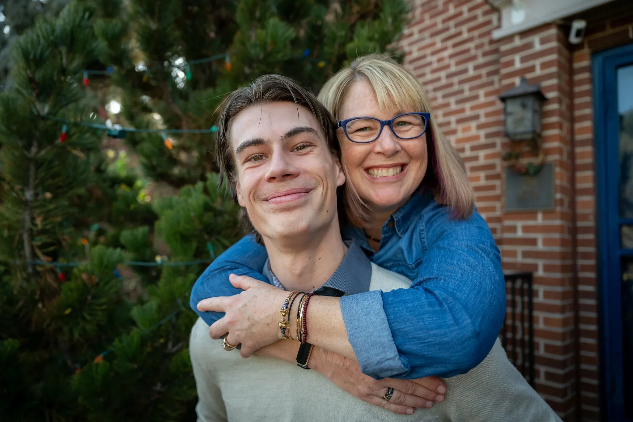 Loving, natural son and mom family portrait in front yard of their home in Denver, Colorado captured by Ryan Kost.