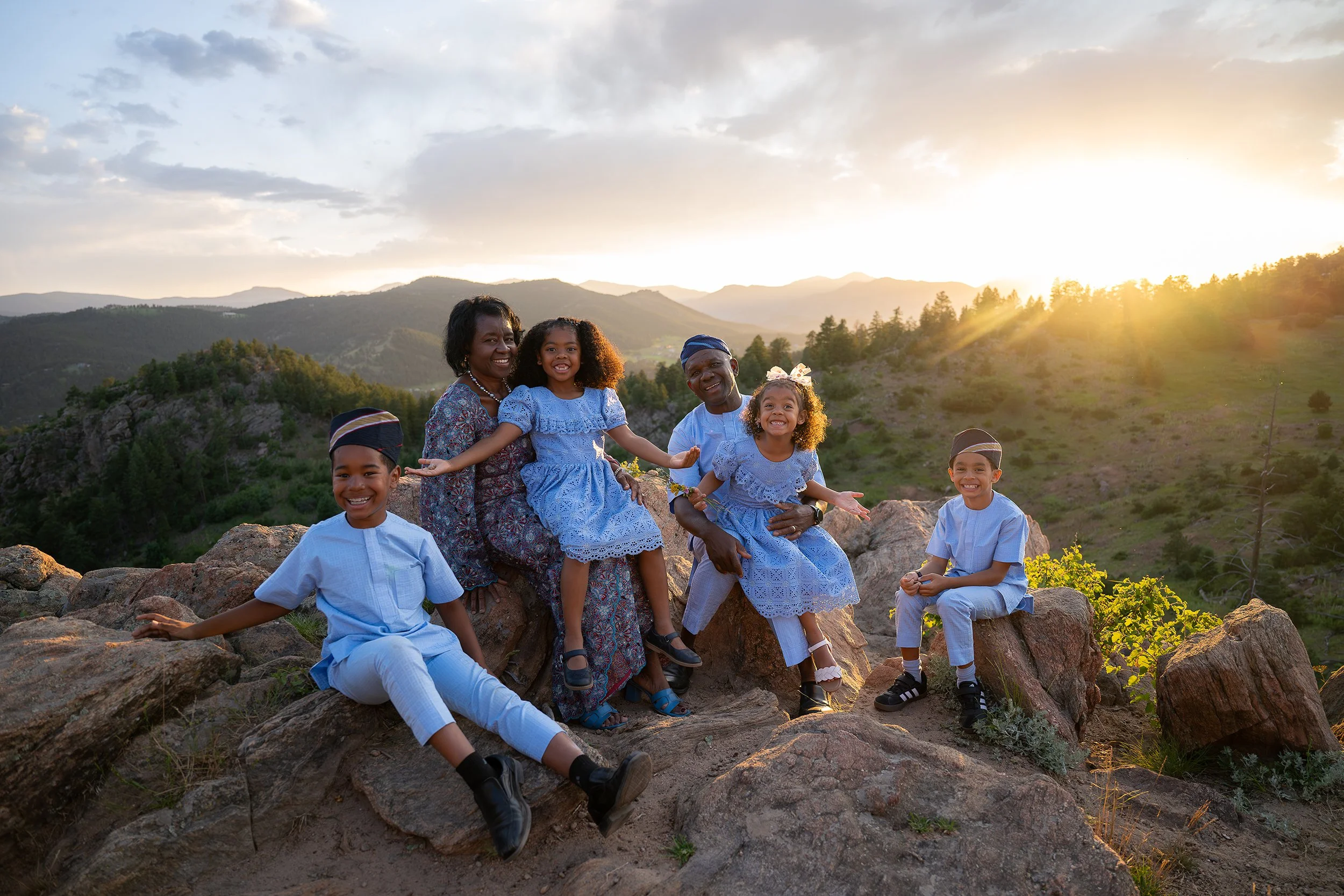 Golden glow at sunset with grandparents proudly sitting on rocks with their grandchildren at Mount Falcon West Trailhead in Colorado beautifully captured by Ryan Kost.