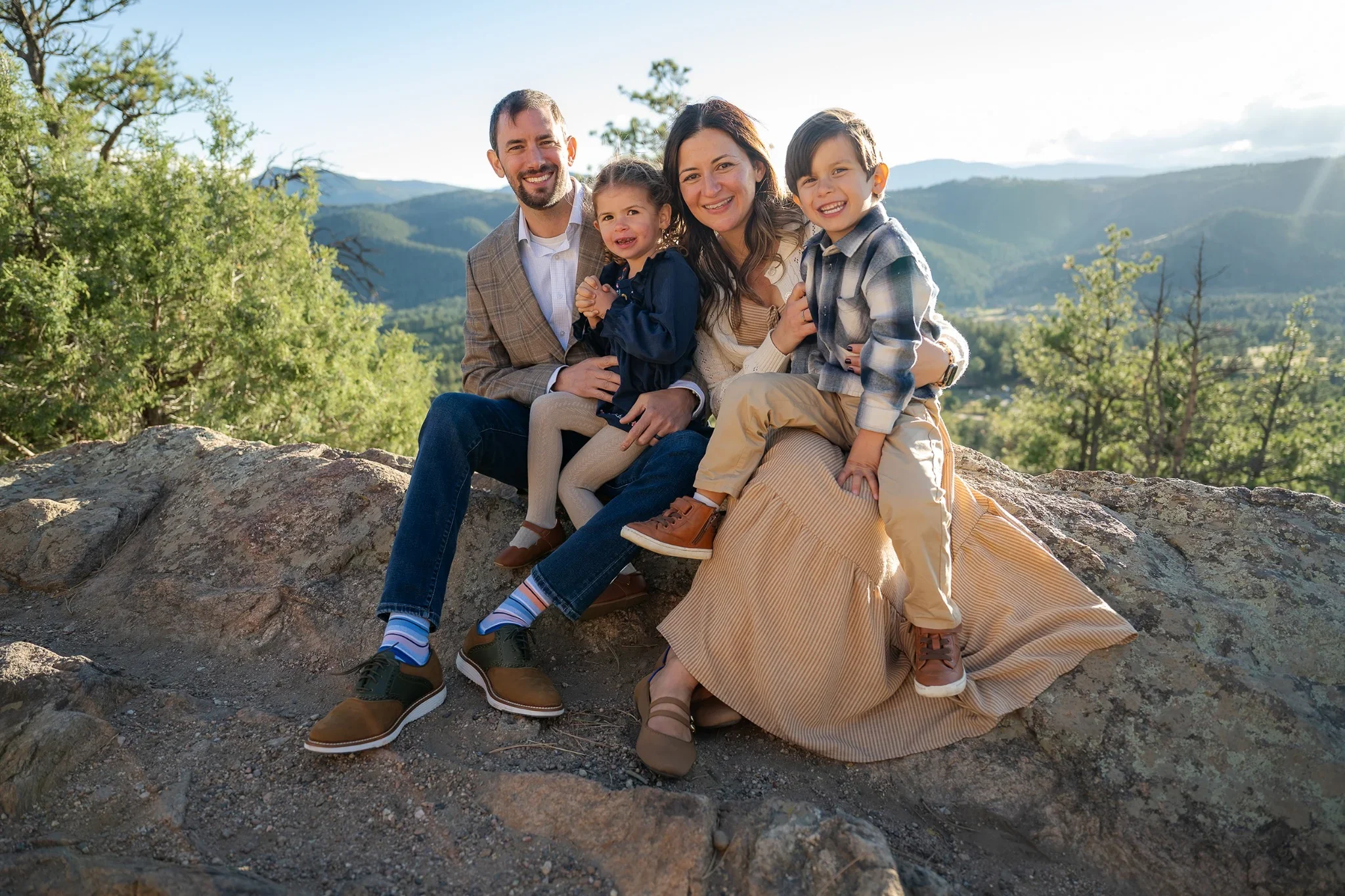 A natural, joyful family portrait during a golden hour family photoshoot at Mount Falcon West in Indian Hills, Colorado captured by Ryan Kost