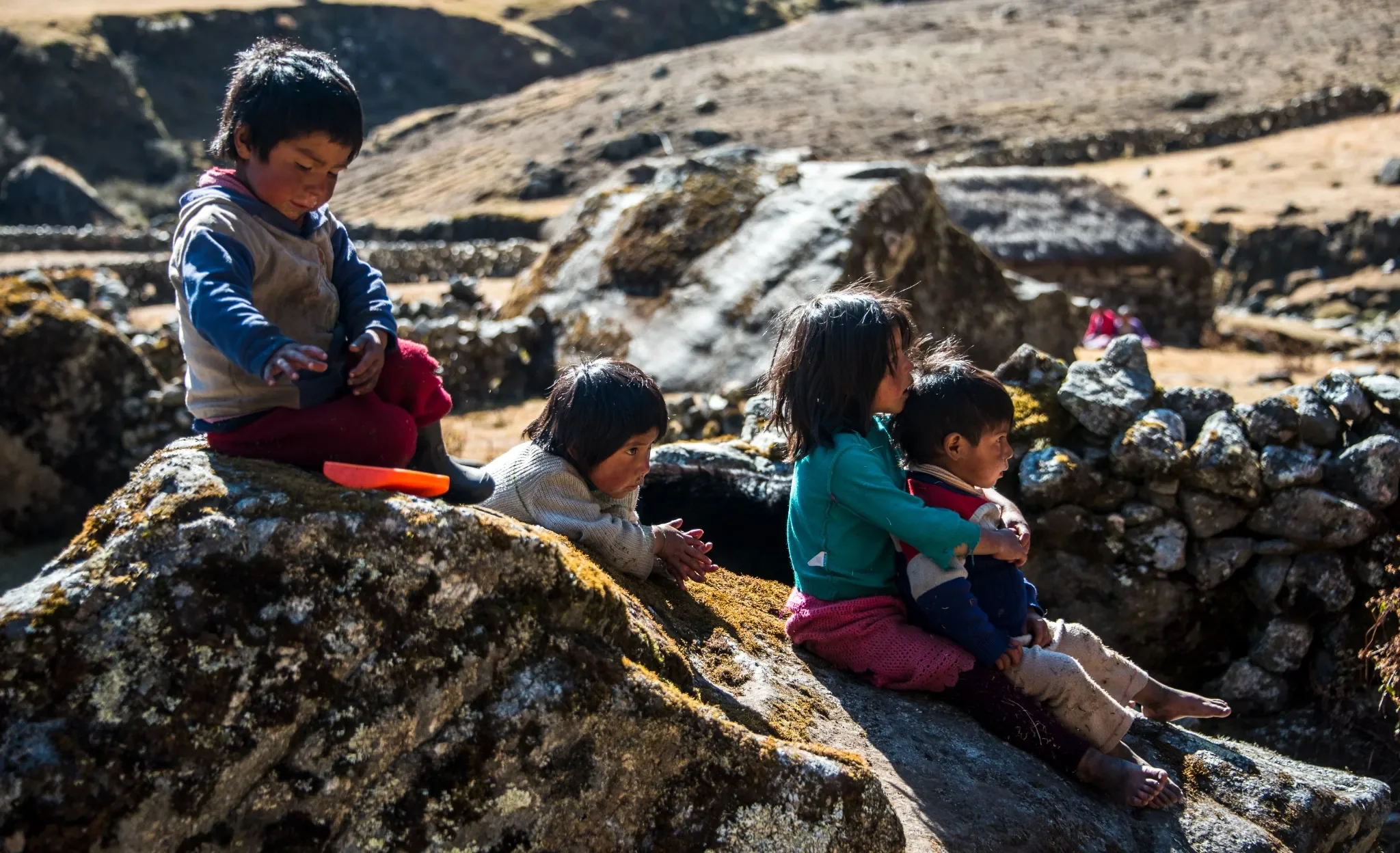 Q'eros-Peru-Siblings-On-Rocks-Ryan-Kost-Photography.webp