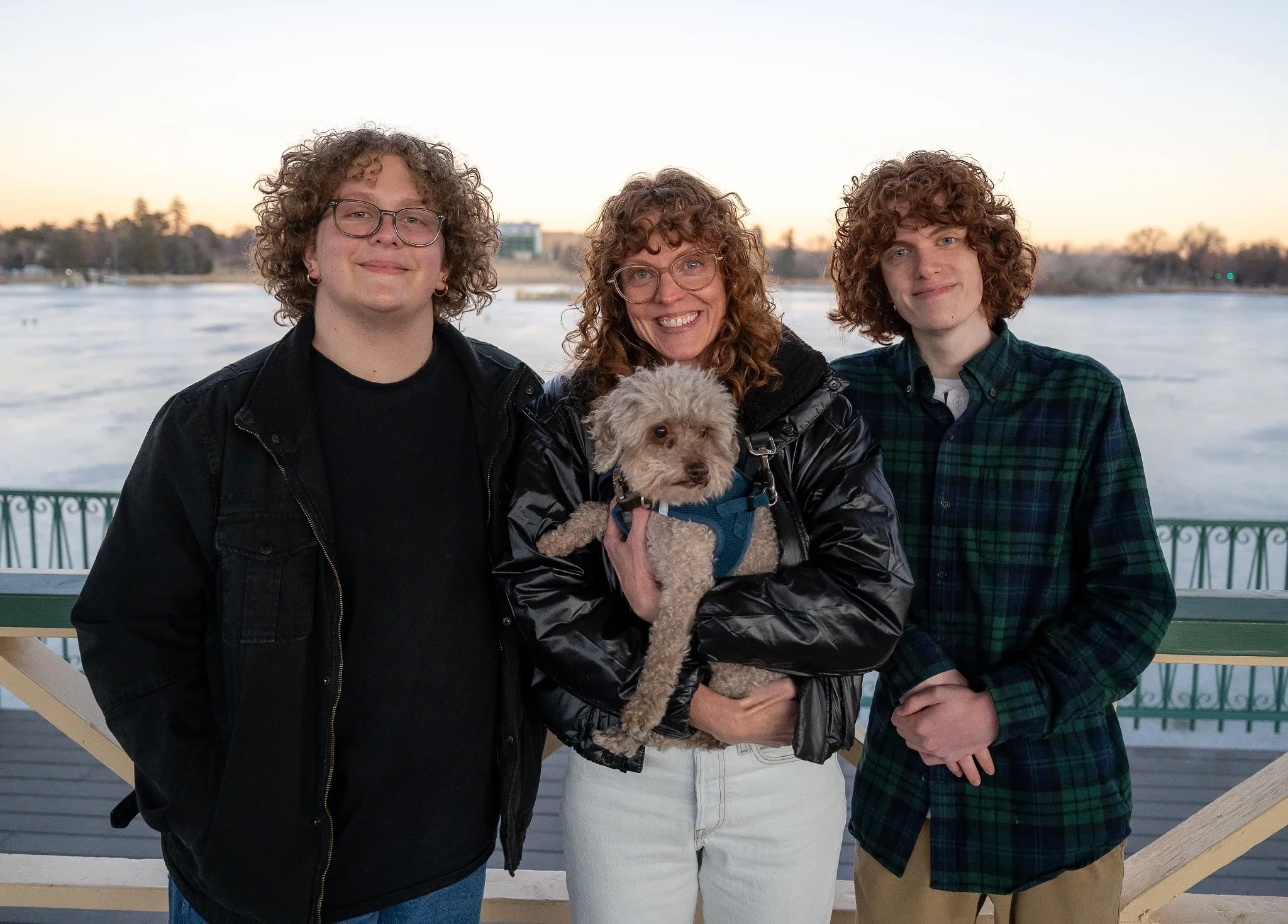 Beautiful, natural family portrait with dog at boathouse pavilion at City Park in Denver, Colorado captured during a winter family photo session by Ryan Kost.