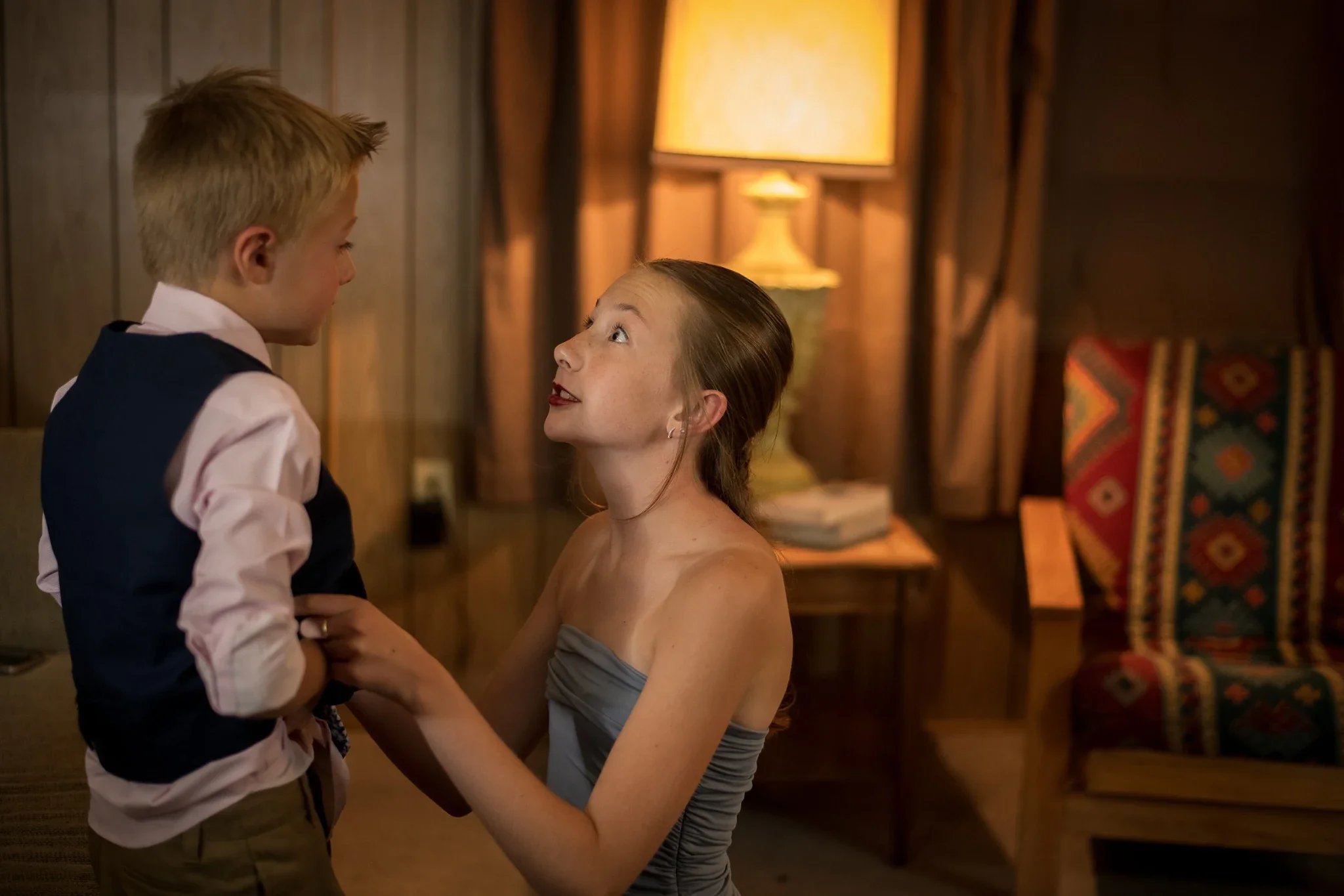 Sister helps her brother get ready for wedding ceremony in cabin at Rocky Mountain Lodge in Horca, Colorado.