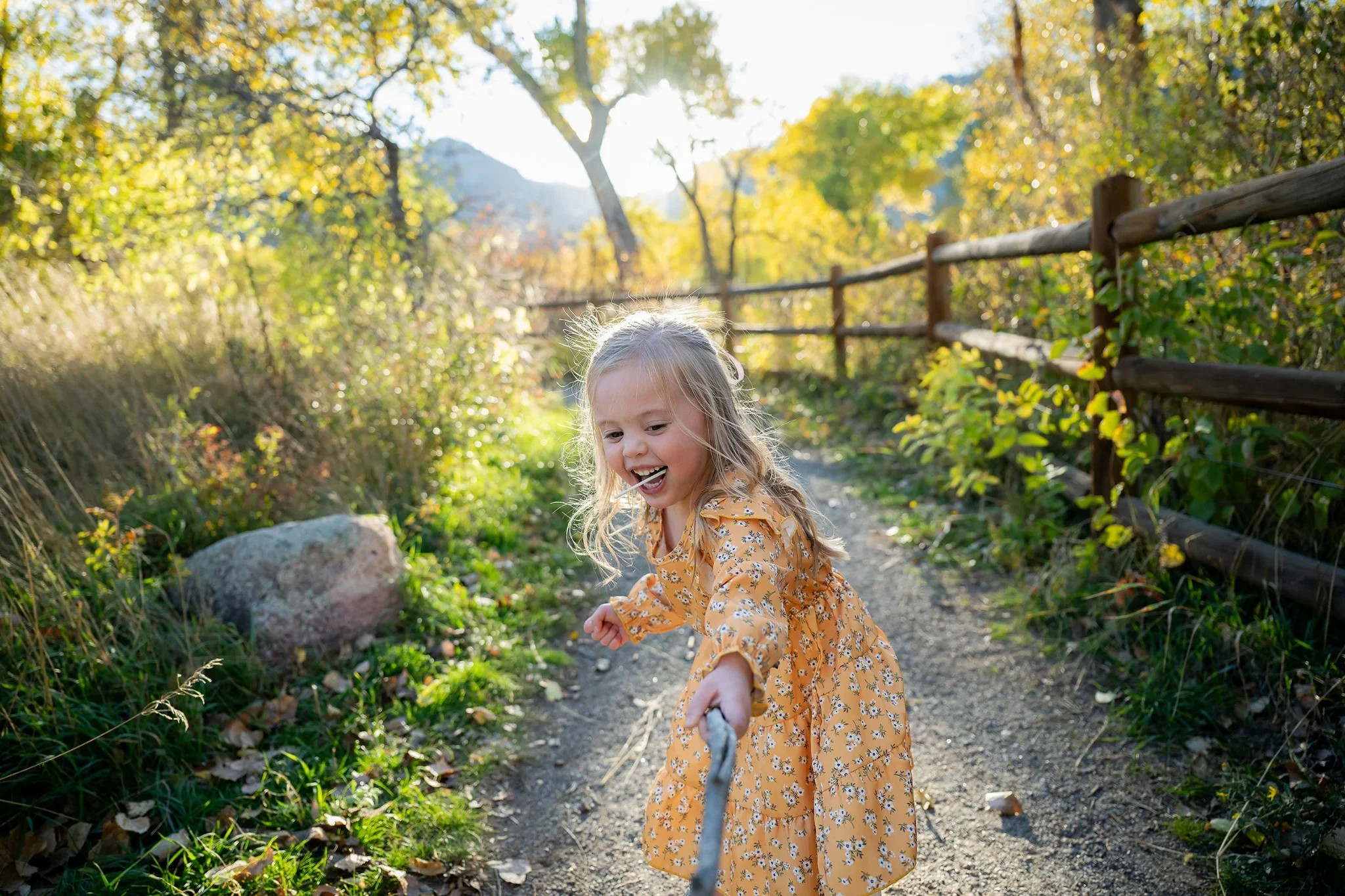 Young girl playfully swordfighting with a stick. South Mesa Trailhead in Boulder, Colorado. Ryan Kost fun family photography.