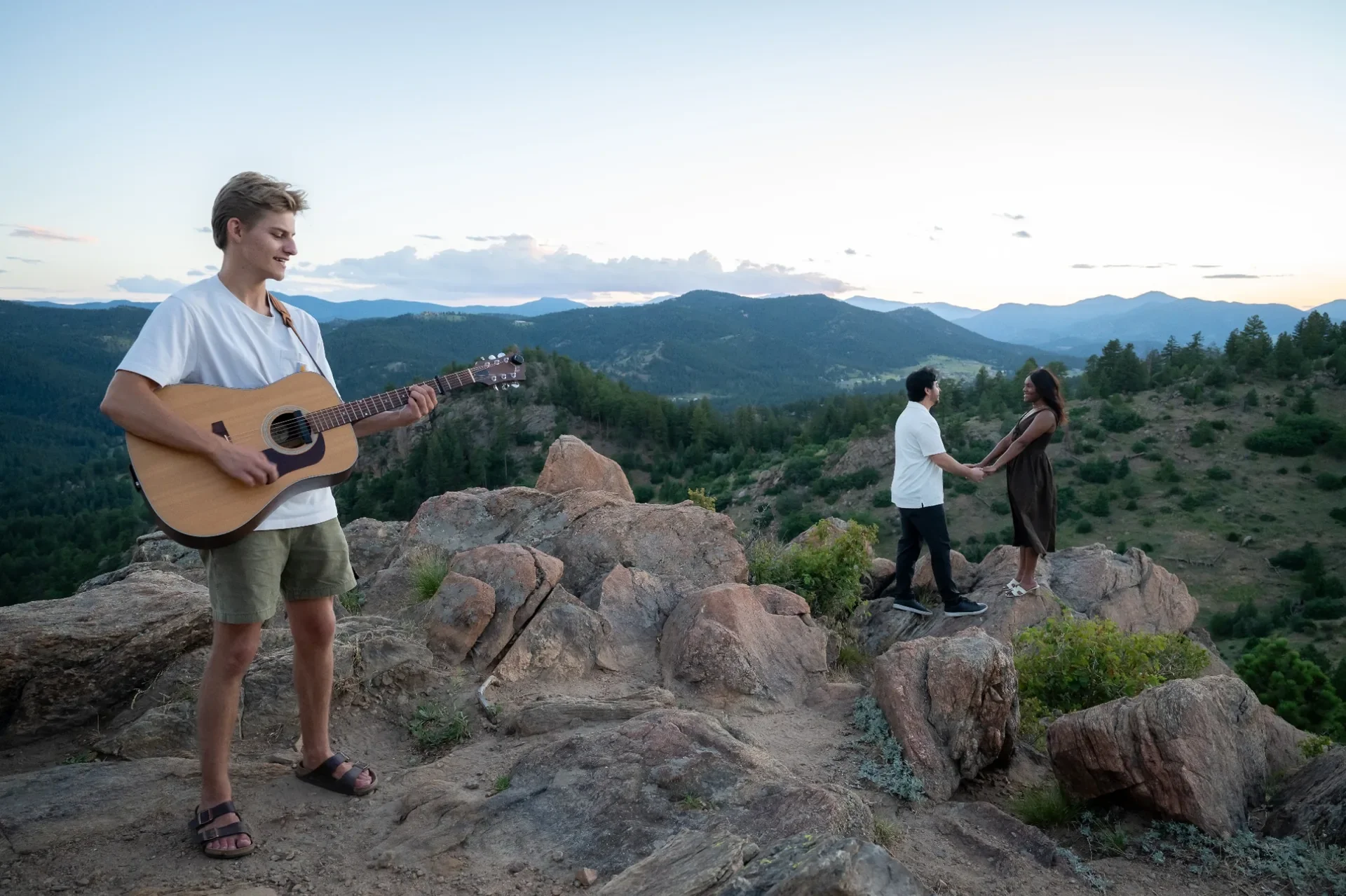 Surprise proposal at Mount Falcon West in Indian Hills, Colorado with live acoustic guitar overlooking the Rocky Mountains at sunset.