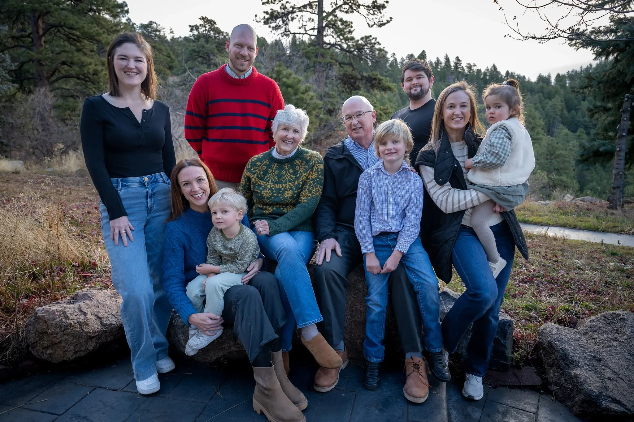 Multi-generational family portrait at an Indian Hills Colorado Airbnb with mountain forest backdrop.