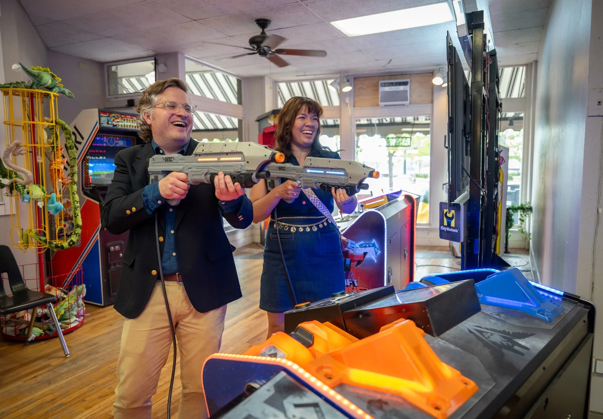 Fun couples portrait at the arcade in Olde Town Arvada celebrating their engagement captured by Ryan Kost.