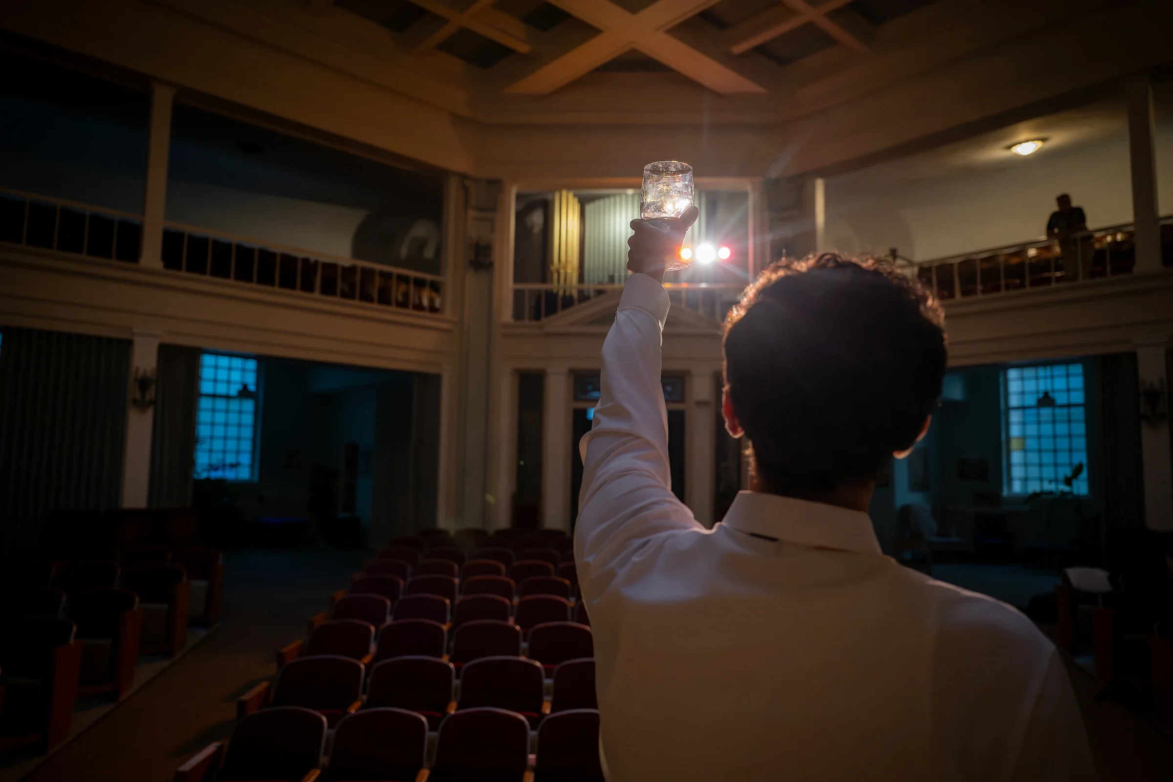Actor raising a champagne toast during the final scene of a Harvey Milk performance at Althea Center in Denver
