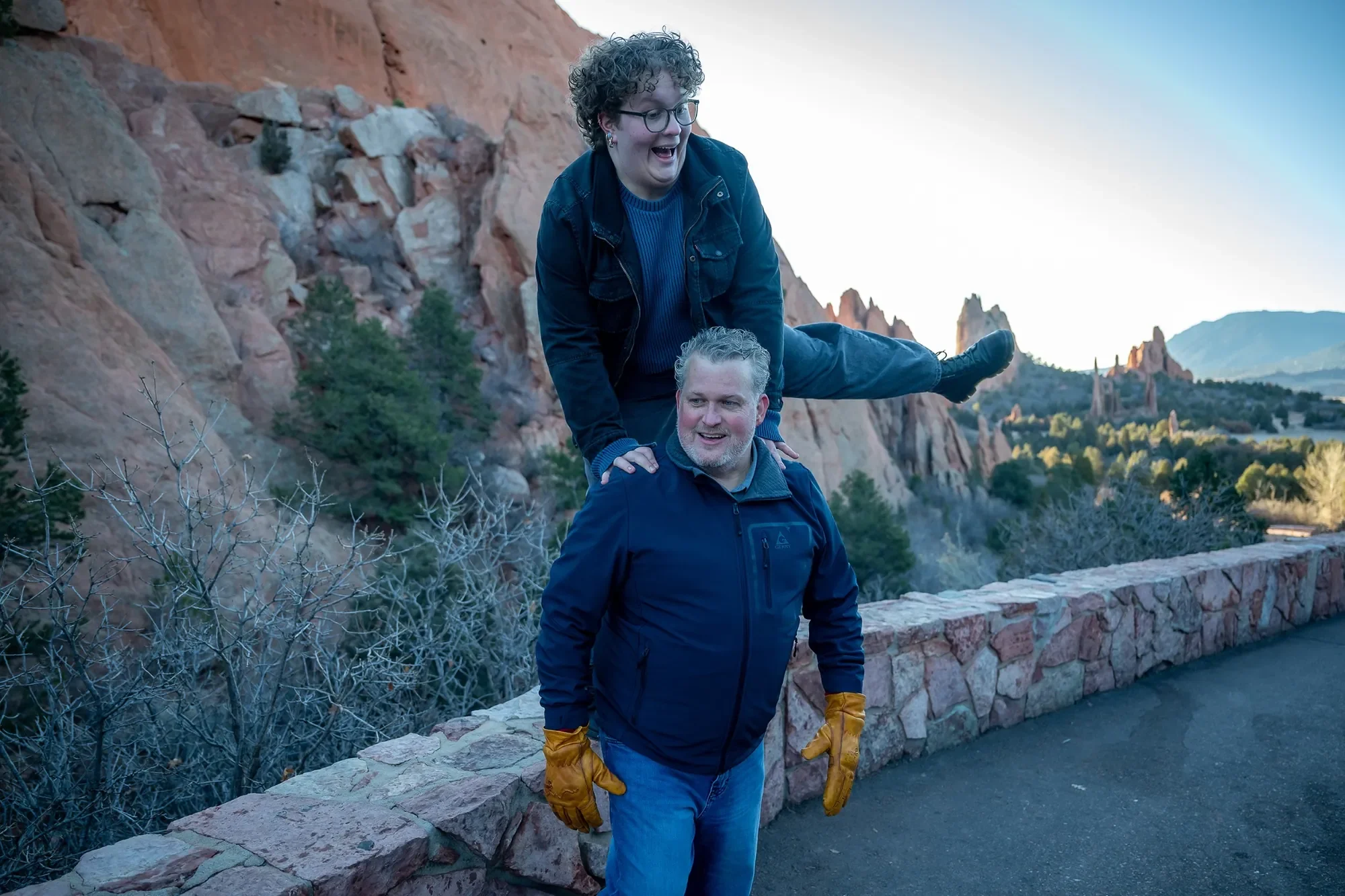 Jumping on dad's back. Fun, relaxed senior portraits at Garden of the Gods captured by Ryan Kost Photography