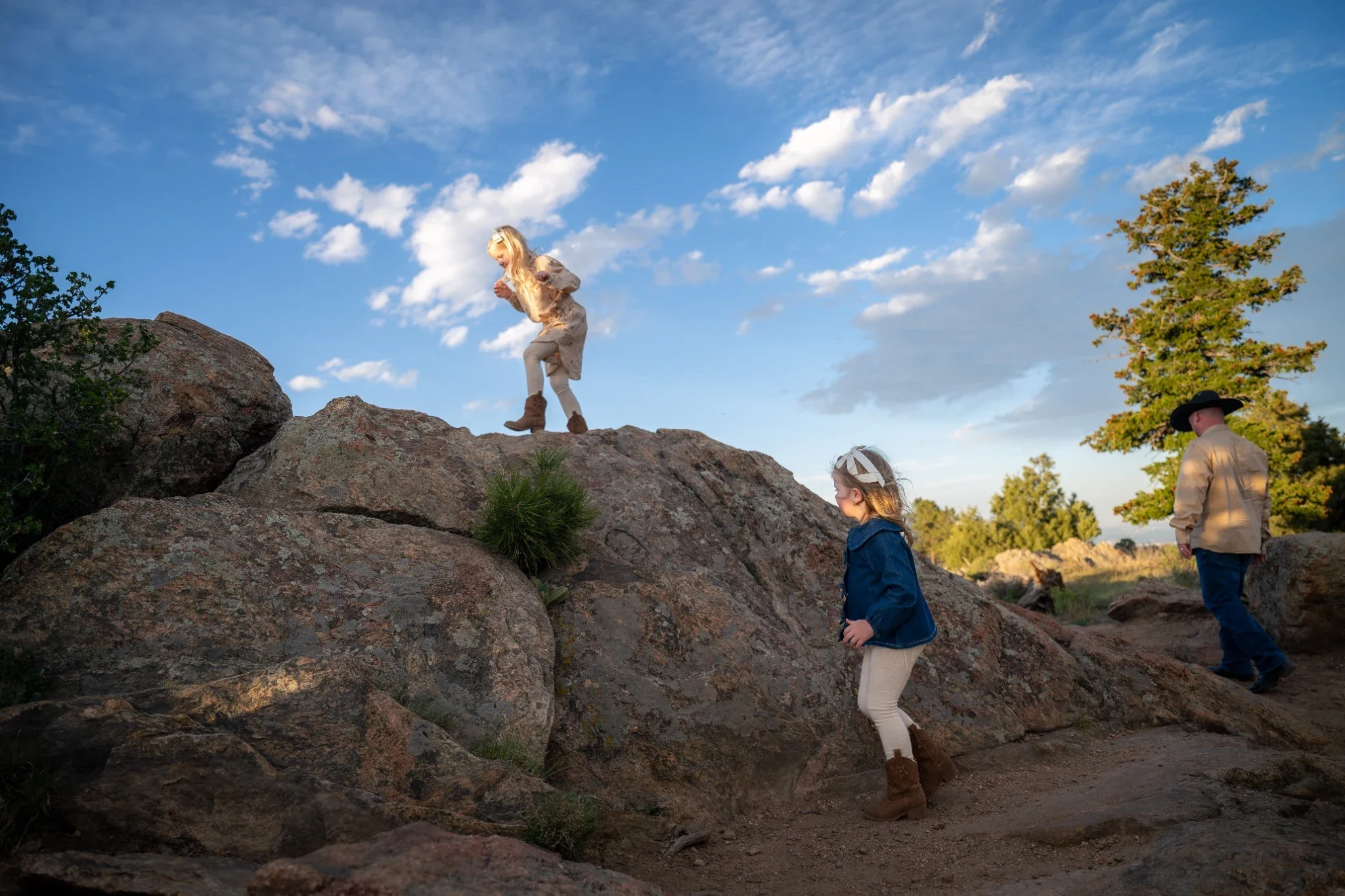 Sisters playing on rocks during a Colorado mountain family photography session at Mount Falcon West in Indian Hills.