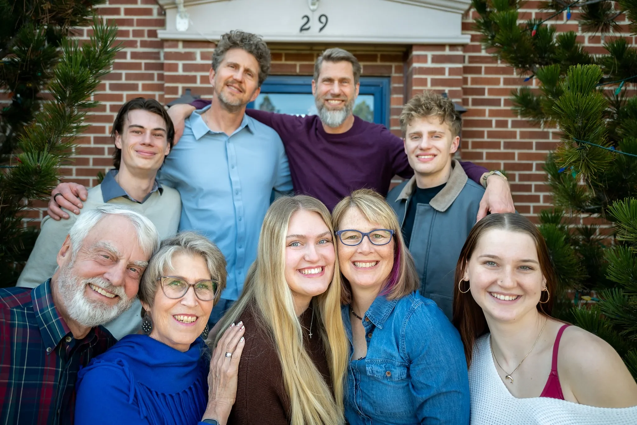 Large, joyful holiday family portrait on front steps of home in Denver, Colorado catpured by Ryan Kost.
