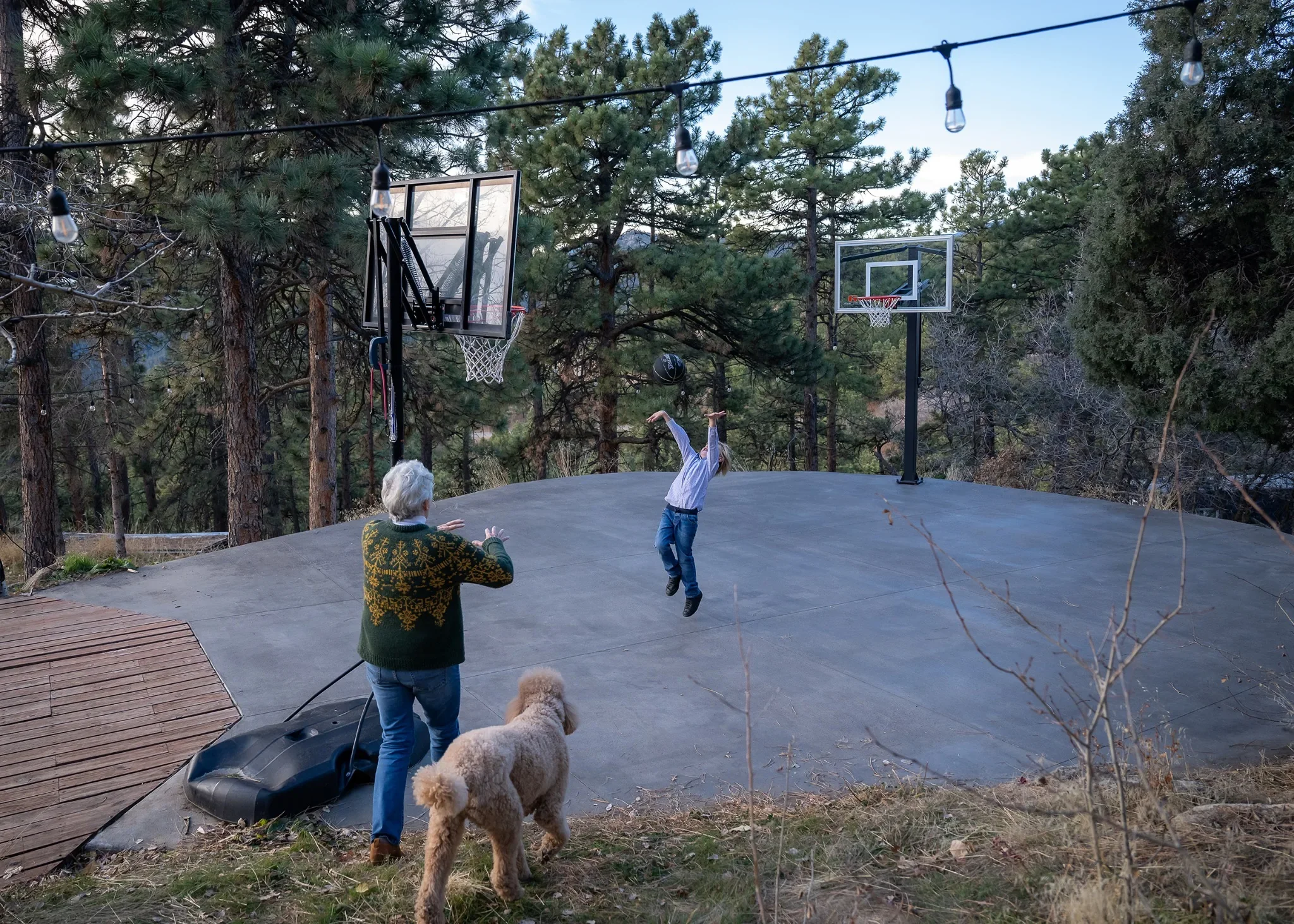 Shooting hoops. Documentary-style family photography playing outdoors at a Colorado mountain rental home in Indian Hills.