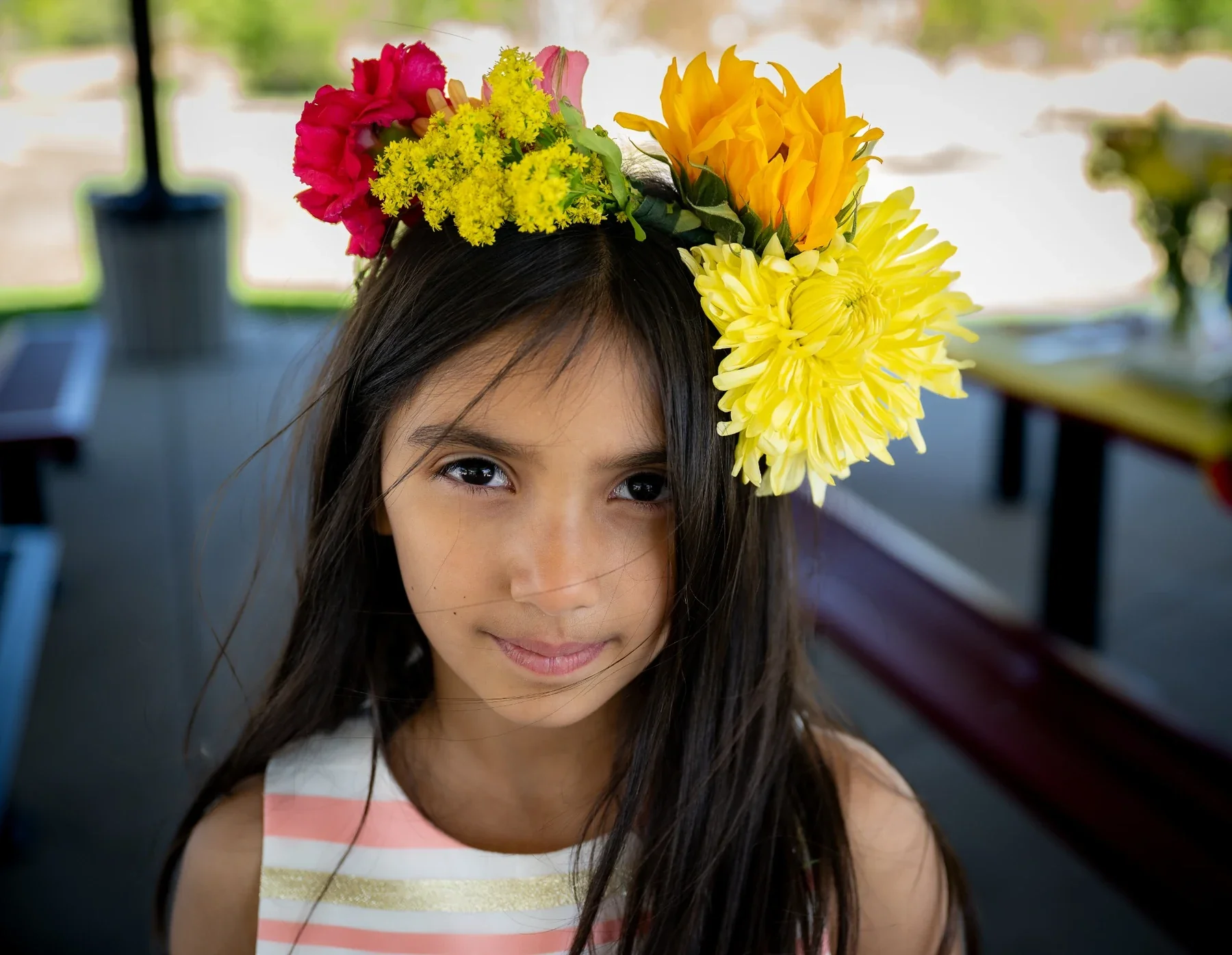 Young girl wearing a colorful flower crown during a playful outdoor family photo session at Broomfield City Park in Broomfield, Colorado by Ryan Kost Photography.