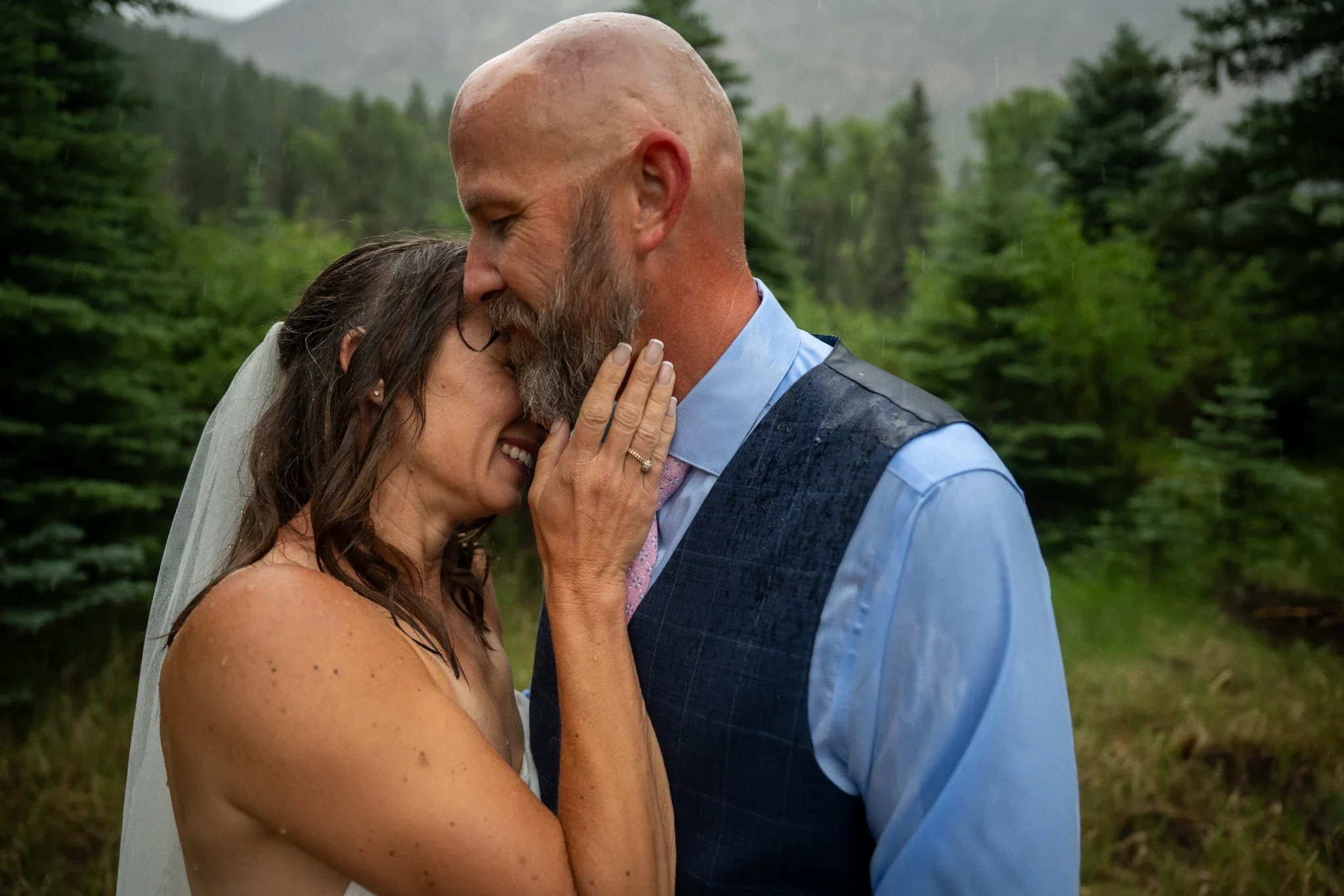 Bride and groom sharing a quiet moment in the rain at a mountain wedding in Horca, Colorado.