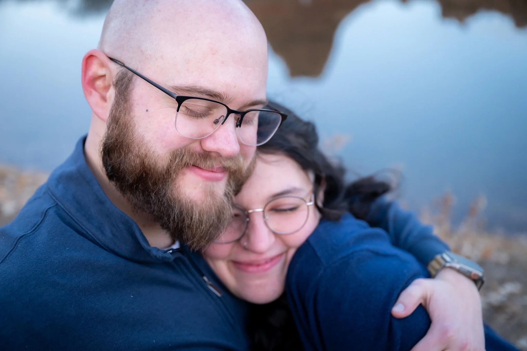 Close-up engagement photo of a couple sharing a quiet hug outdoors at South Valley Park in Littleton, Colorado, documentary photography by Ryan Kost
