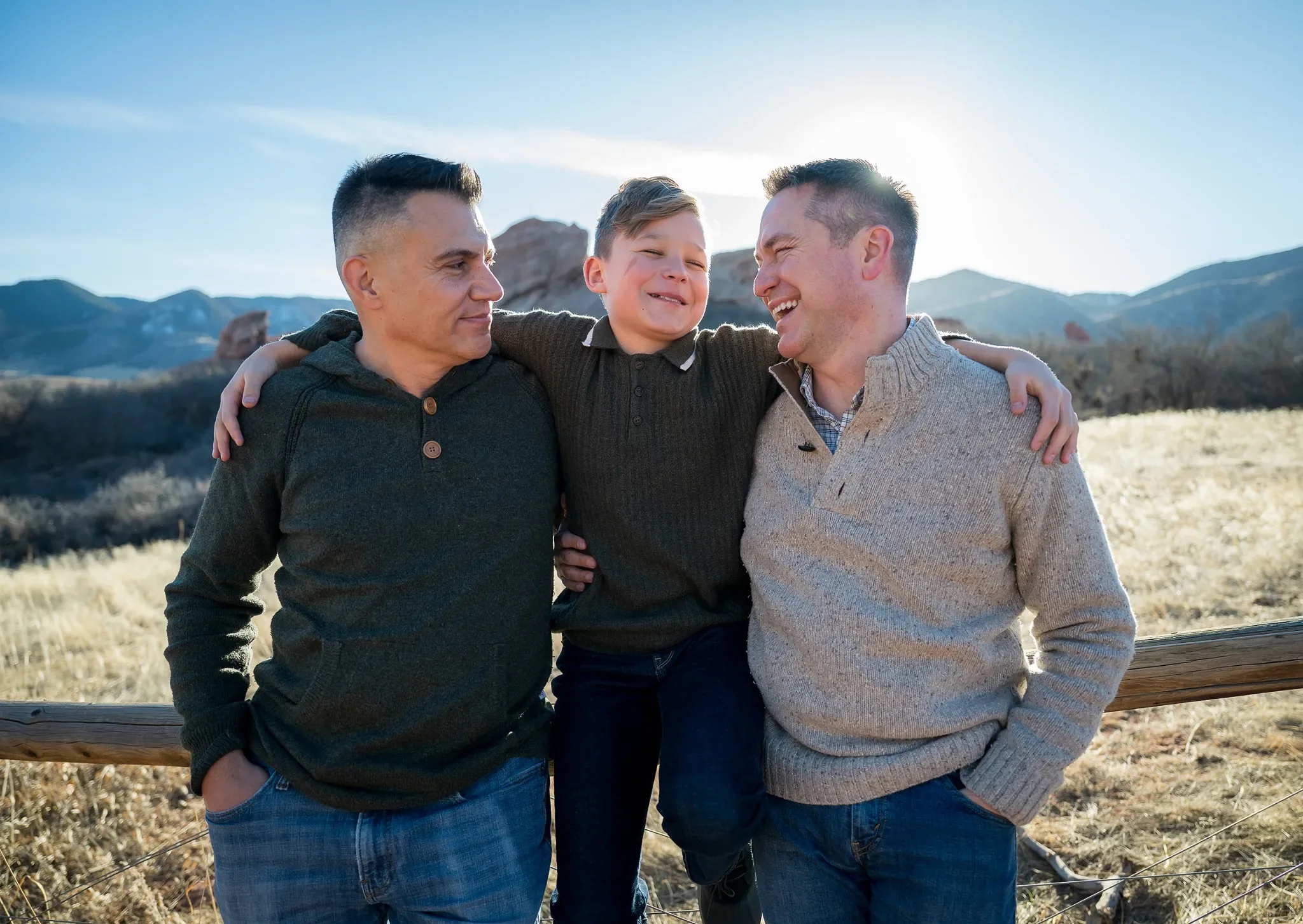 Dad's and son sitting on fence during an outdoor family photography session at South Valley Park Littleton Colorado.