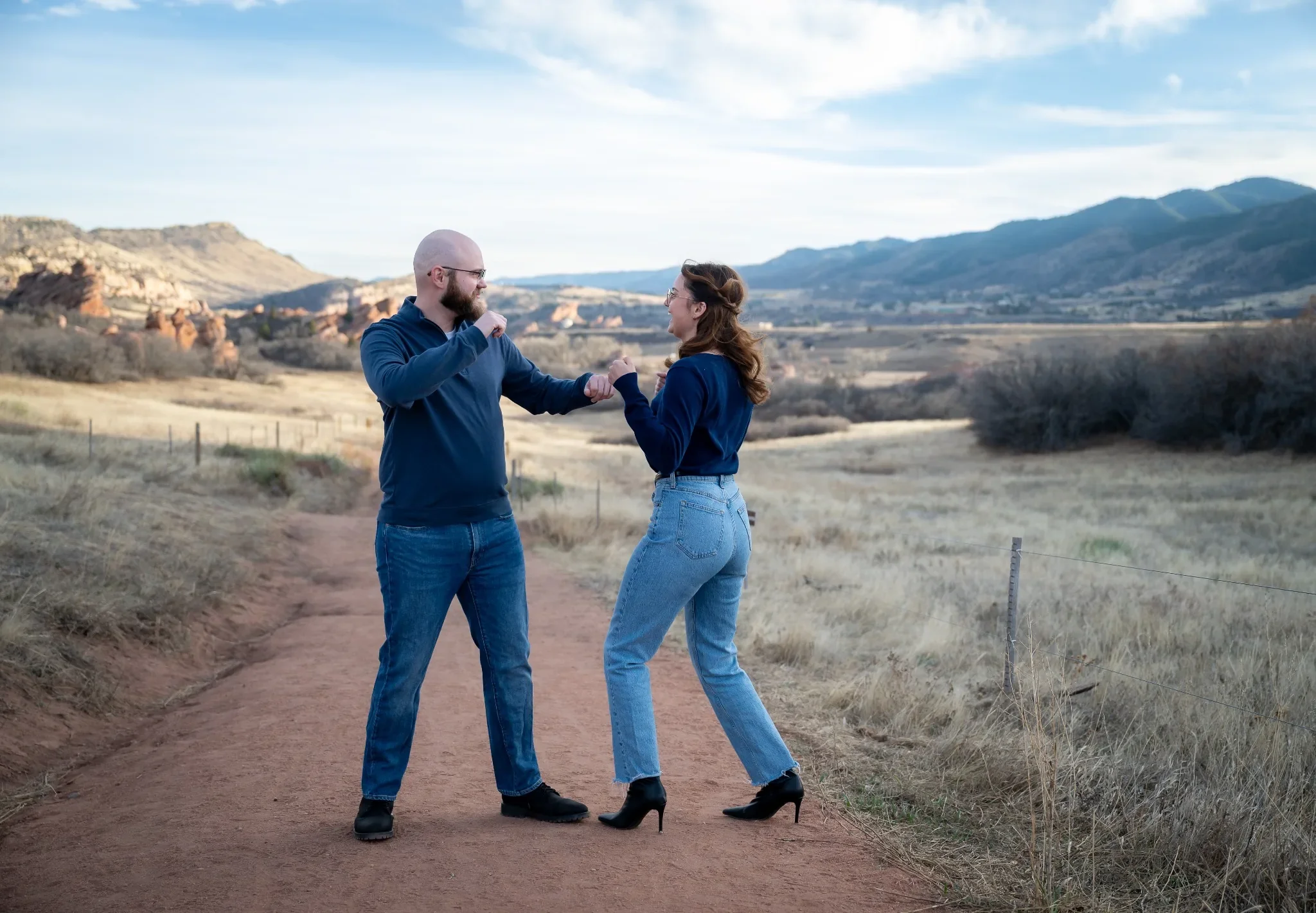 Siblings playfully boxing on the trail with beautiful red rock back drop at South Valley Park in Littleton, Colorado captured by Ryan Kost.