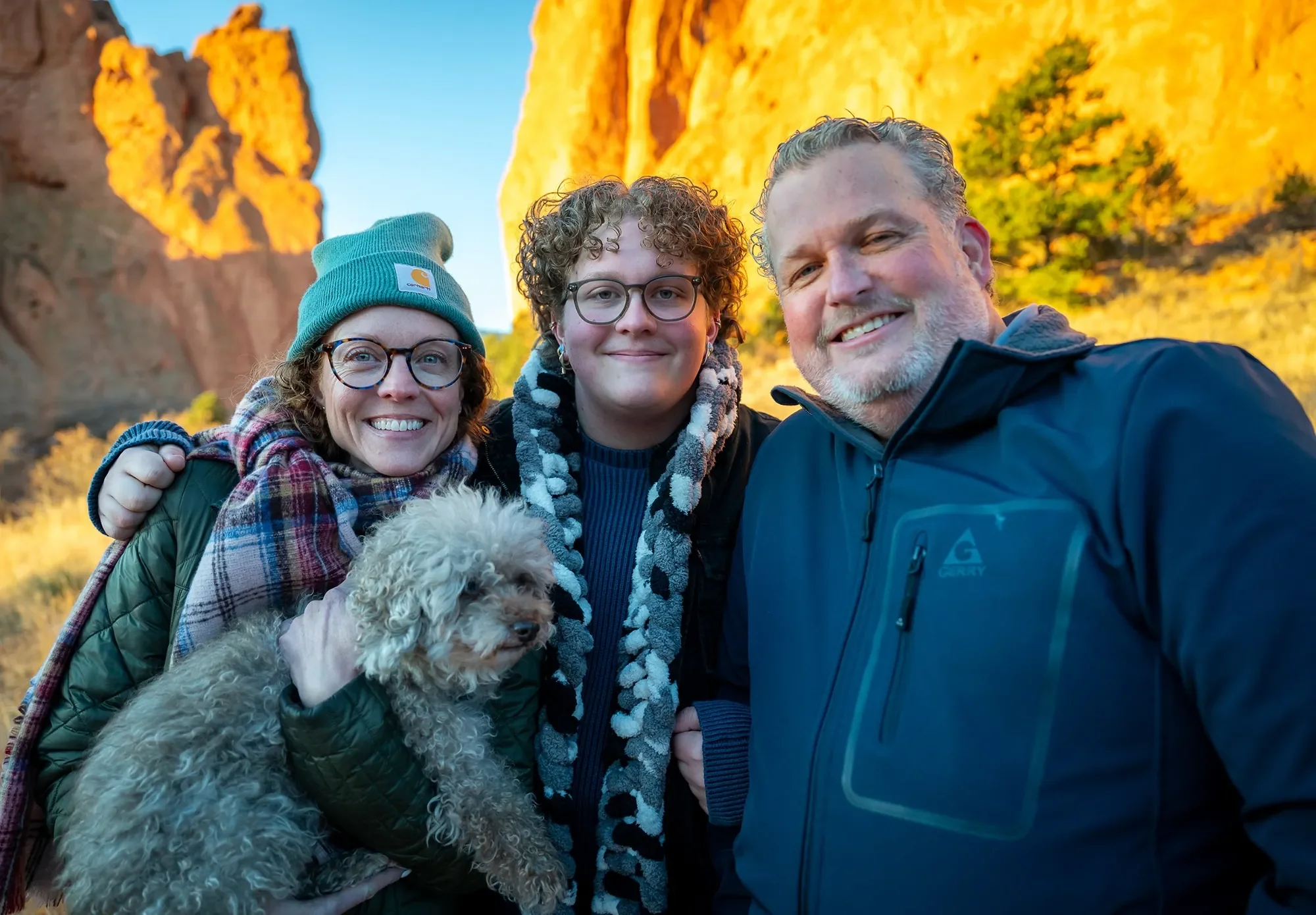 Joyful, natural family portrait captured during a high school senior photo sunrise session at Garden of the Gods by Ryan Kost.