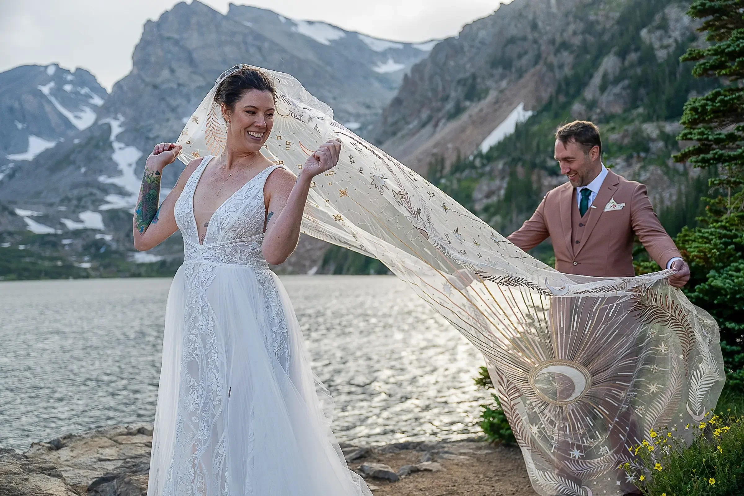 Groom admiring bride's beautiful veil during an intimate summer elopement at Lake Isabelle in Indian Peaks Wilderness. Ryan Kost Photography