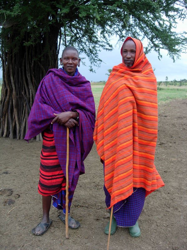 Two Maasai pastoralists in northern Tanzania wearing traditional shúkà cloth, photographed near their village beneath the shade of an acacia tree. Ryan Kost Photography