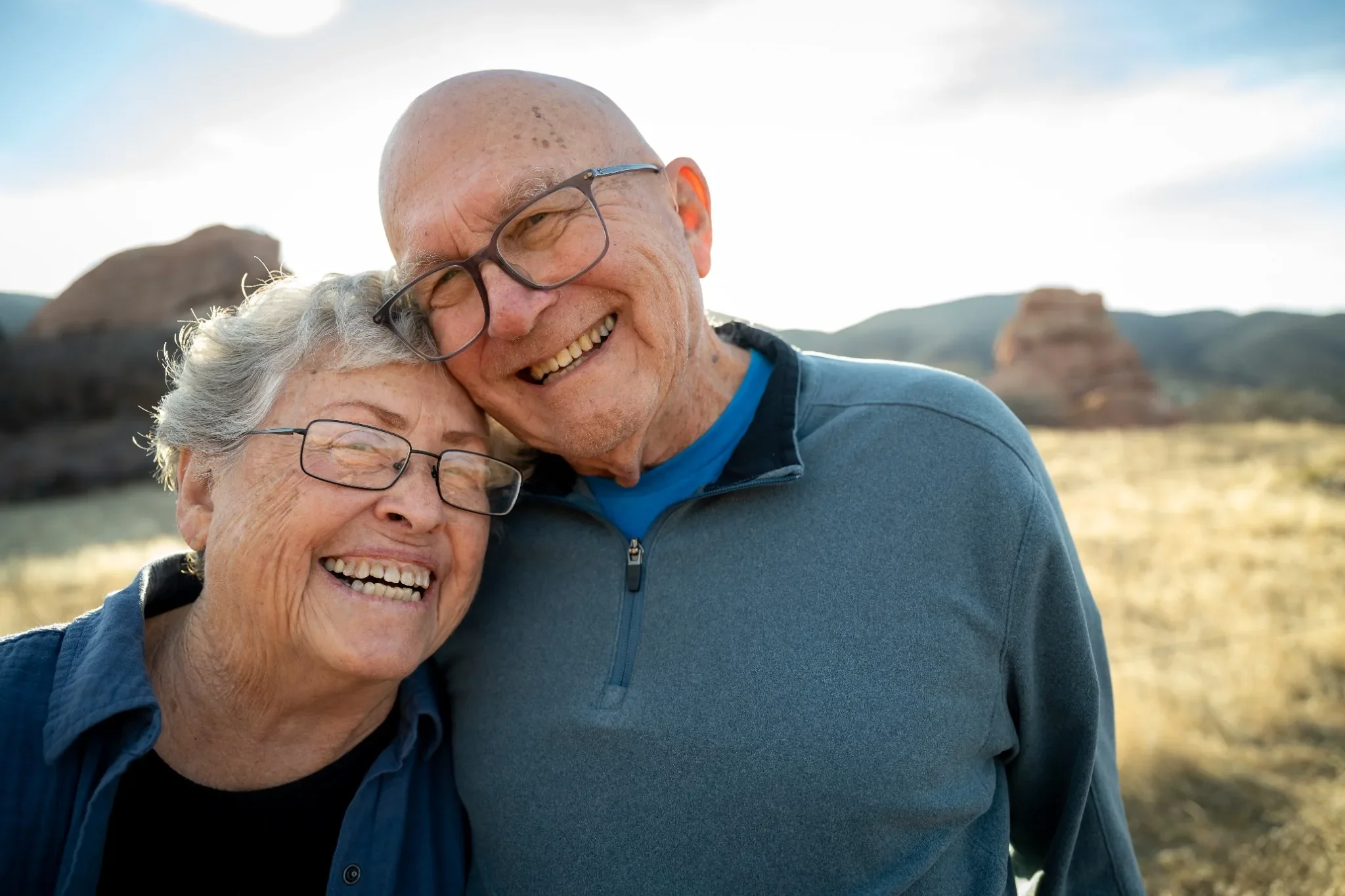  Couple smiling together during a multi-generation family photo session at South Valley Park in Colorado. Ryan Kost Photography.