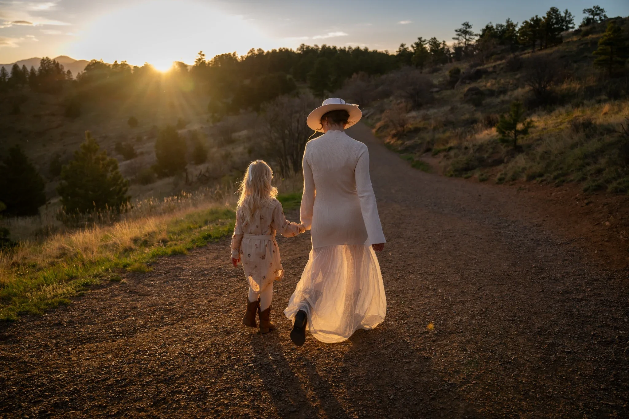 Mother and daughter walking together at sunset during a Colorado mountain family photography session at Mount Falcon West.