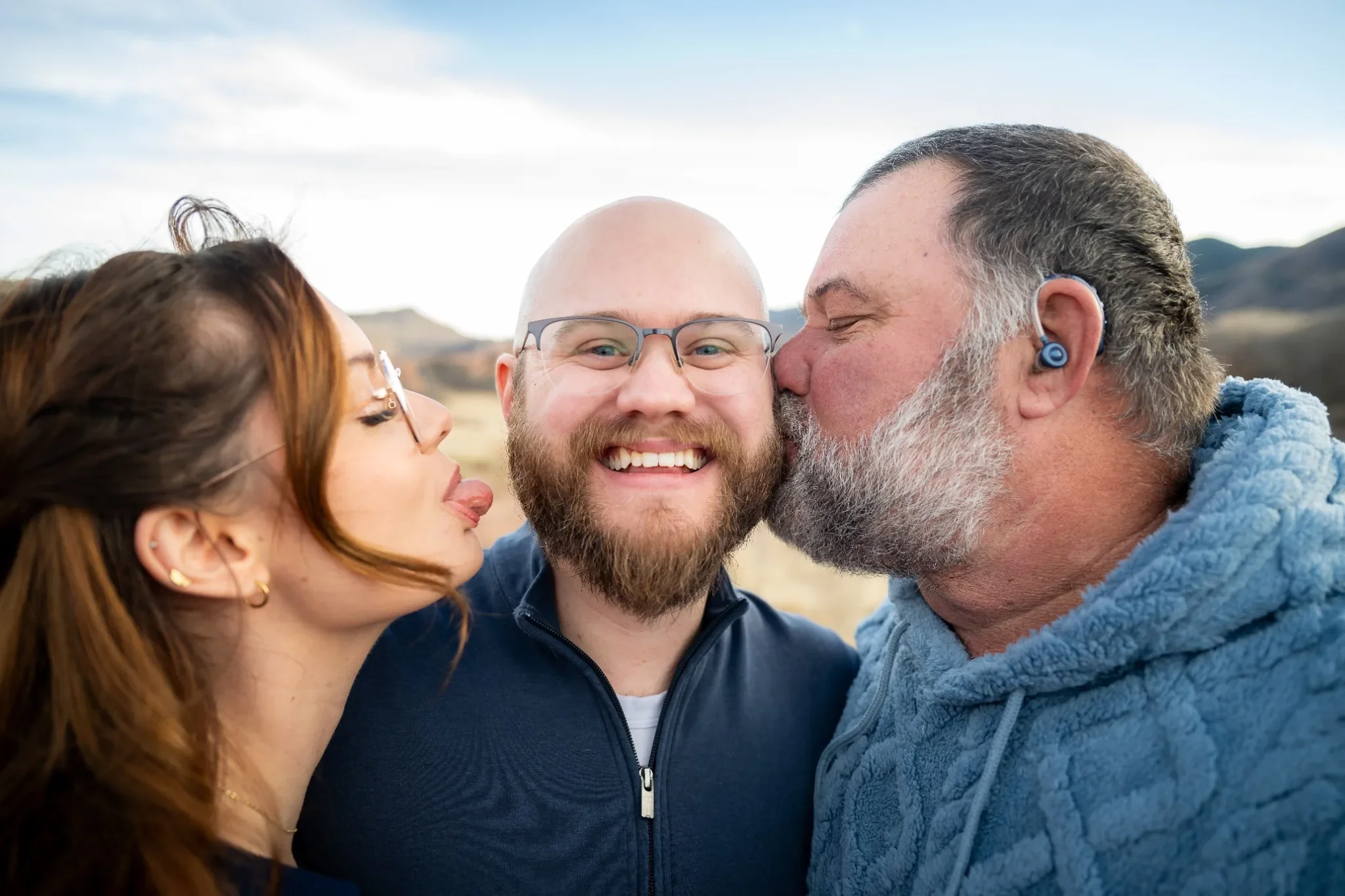 Silly siblings and dad family portrait captured by Ryan Kost during a winter family photo session at South Valley Park in Littleton, Colorado.