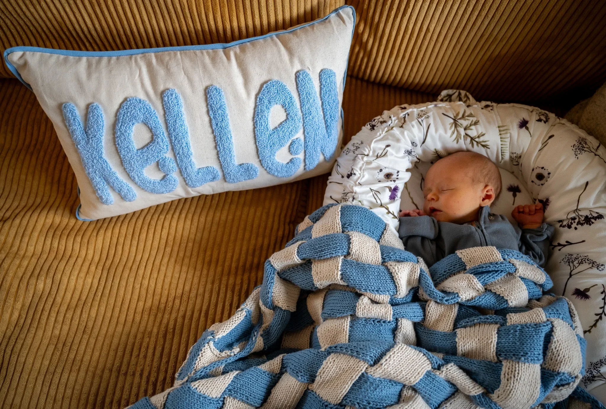 My son sleeping in his blanket that his great auntie made for him and his new pillow on our couch at home in Arvada, Colorado. Ryan Kost Photography