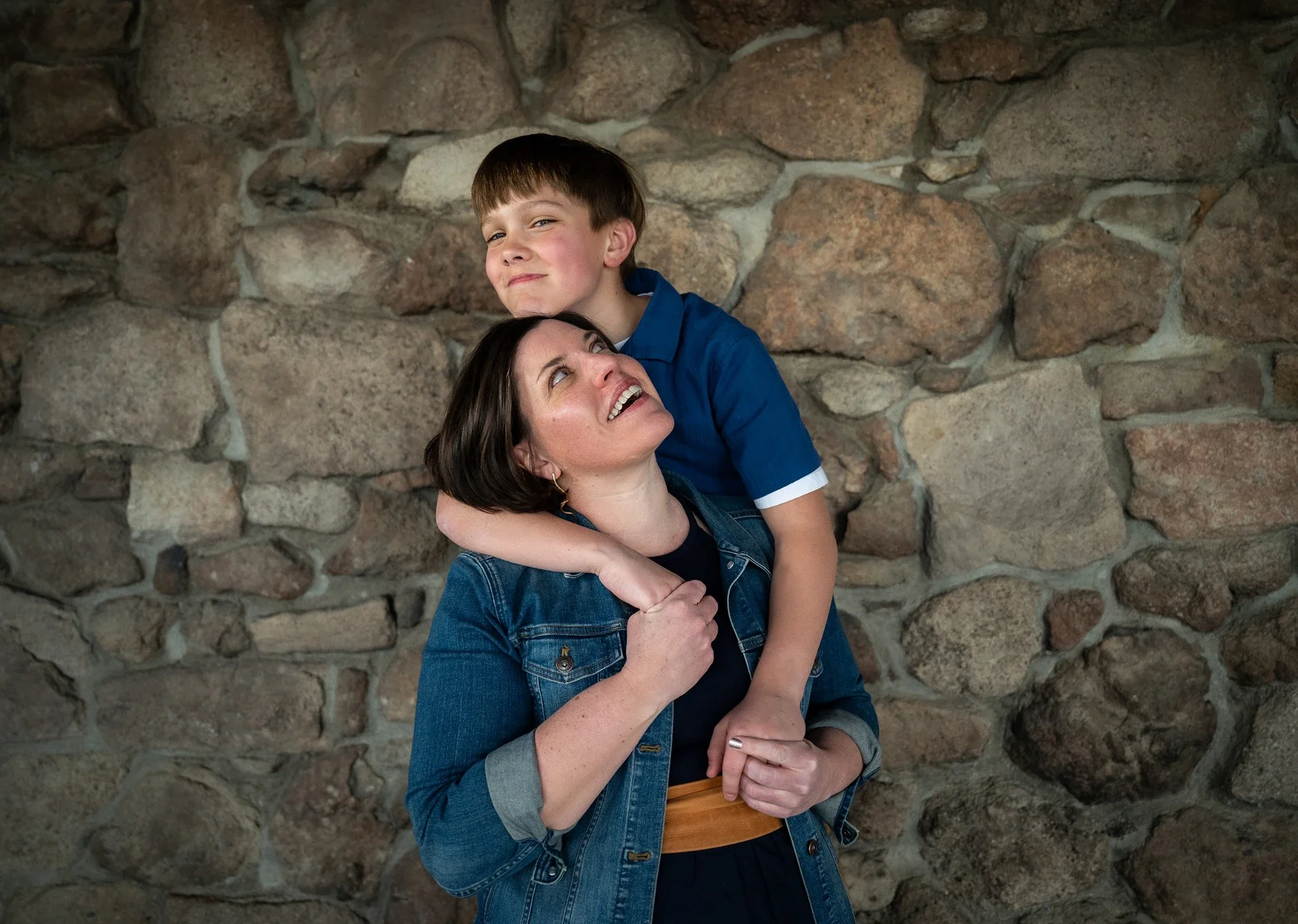 Mother and son sharing a playful hug during a relaxed family photo session at Daniels Park in Sedalia, Colorado.