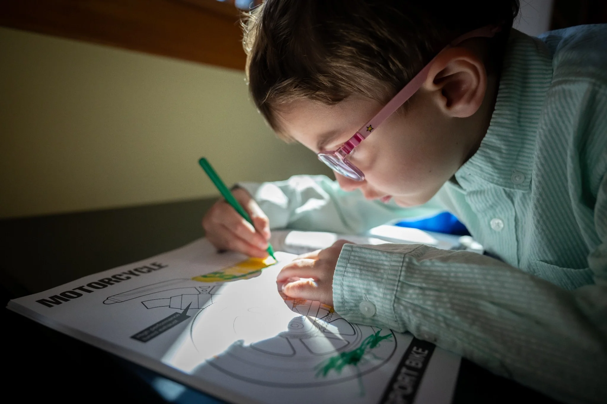 Candid moment of a child coloring at home during an in-home family photography session in Evergreen, Colorado, captured by documentary family photographer Ryan Kost.