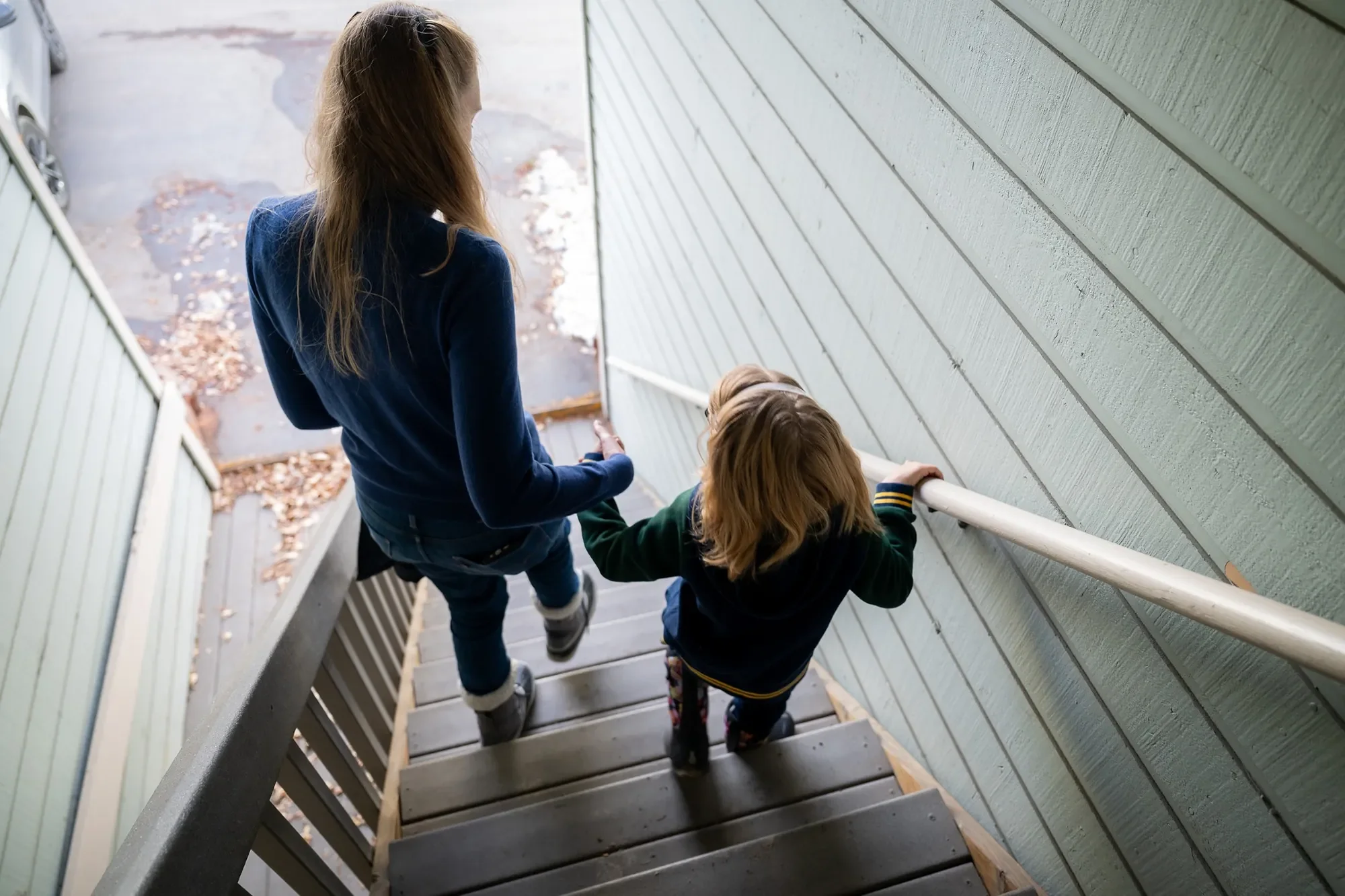Mom & daughter walking stairs in Fraser, Colorado captured by Ryan Kost.
