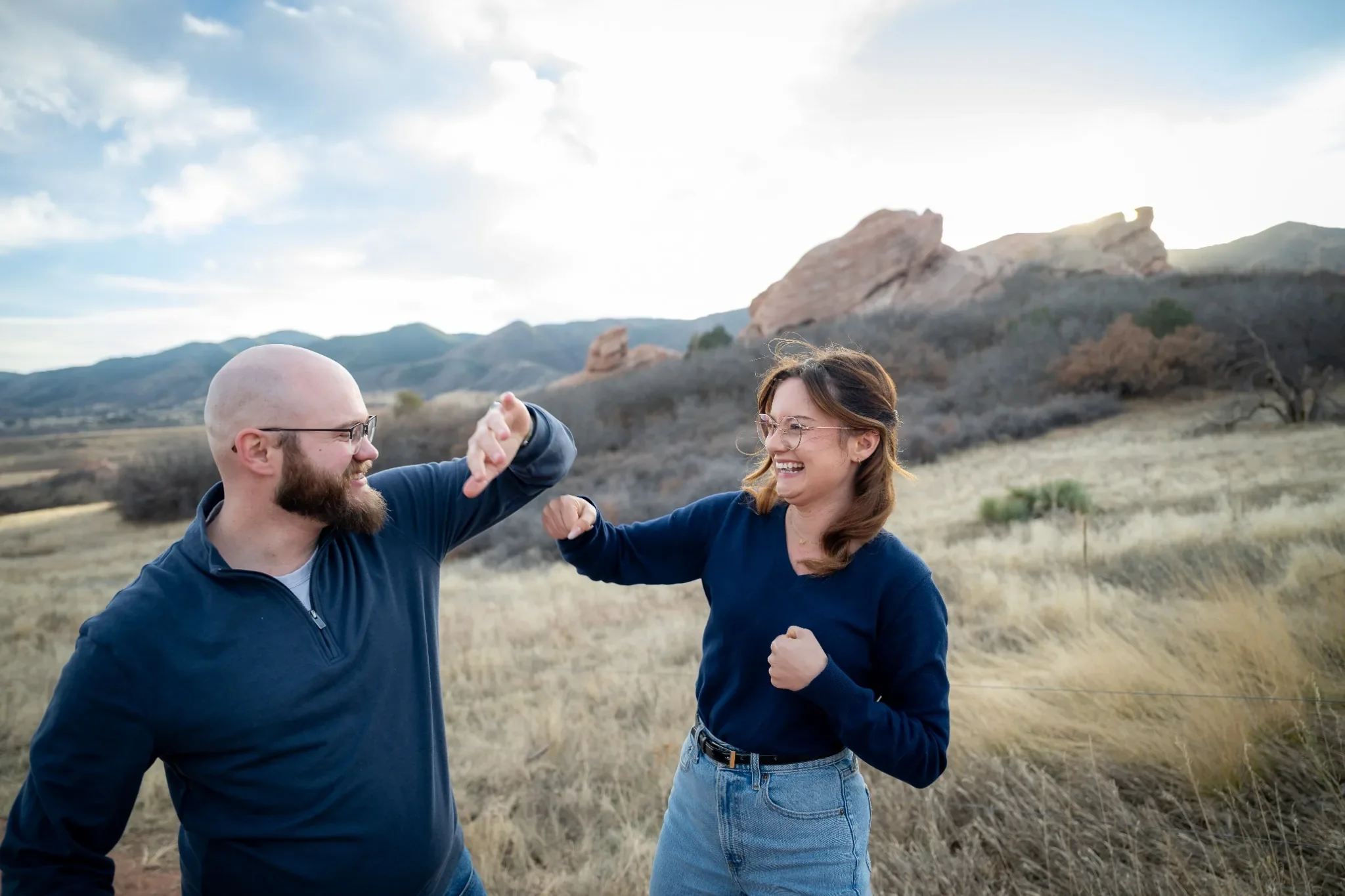 Twin siblings laughing and playfully interacting during a candid family photo session at South Valley Park in Littleton, Colorado