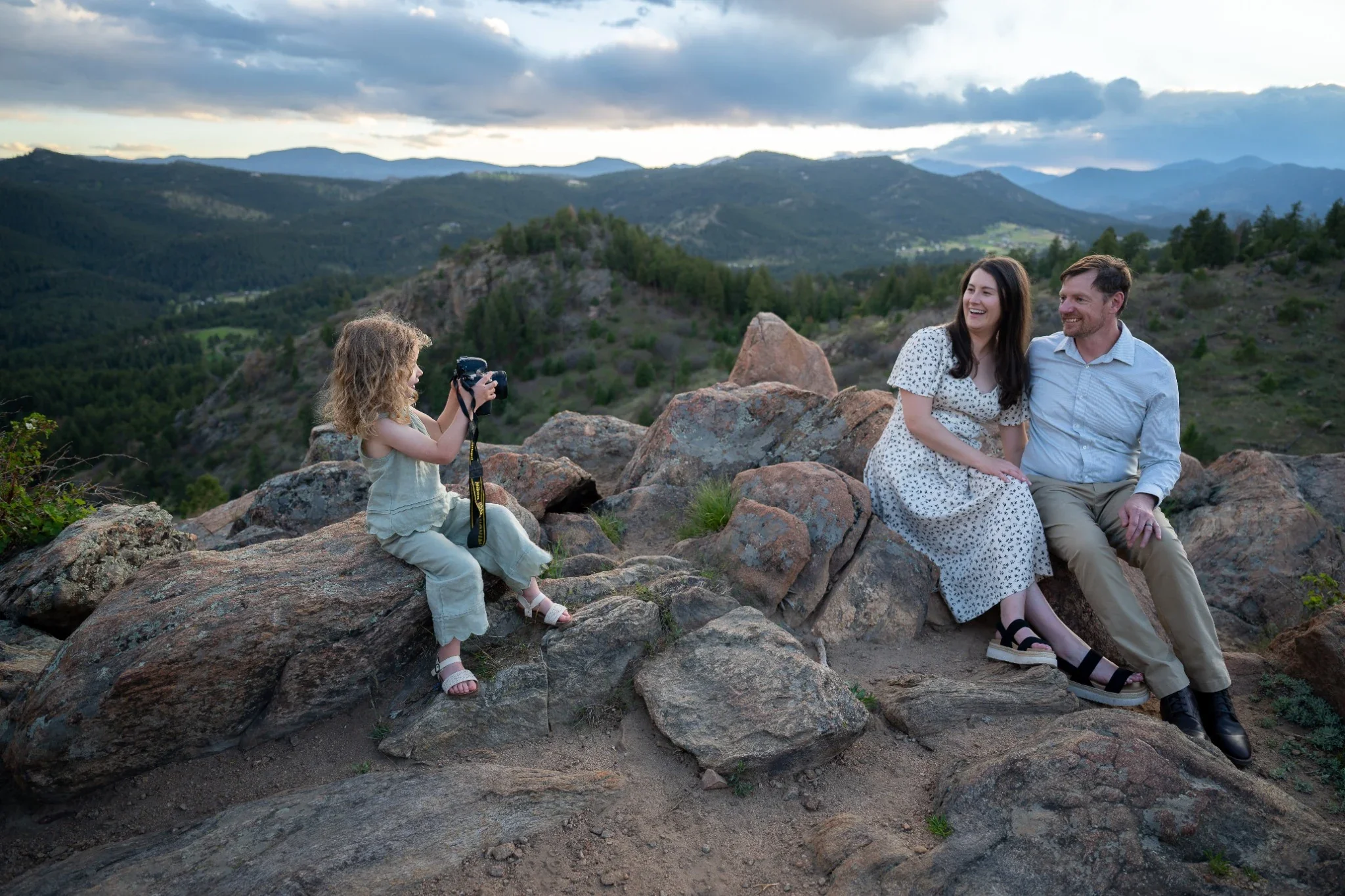 Family portrait of daughter taking a photo of her parents at Mount Falcon West Trailhead in Indian Hills, Colorado. 