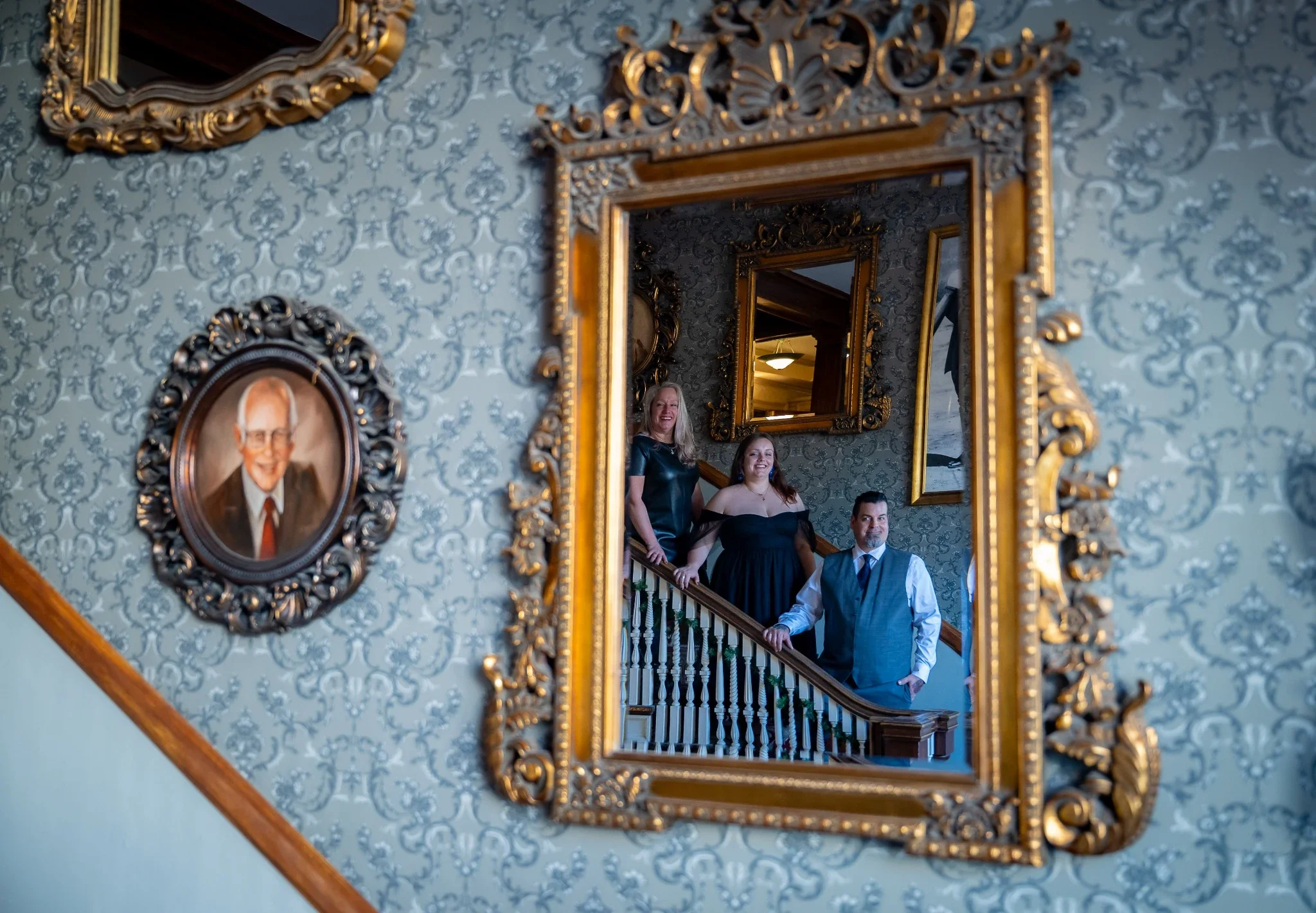 Family portrait reflected in ornate mirror at the Stanley Hotel in Estes Park Colorado during an elegant mountain family photography session by Ryan Kost Photography 