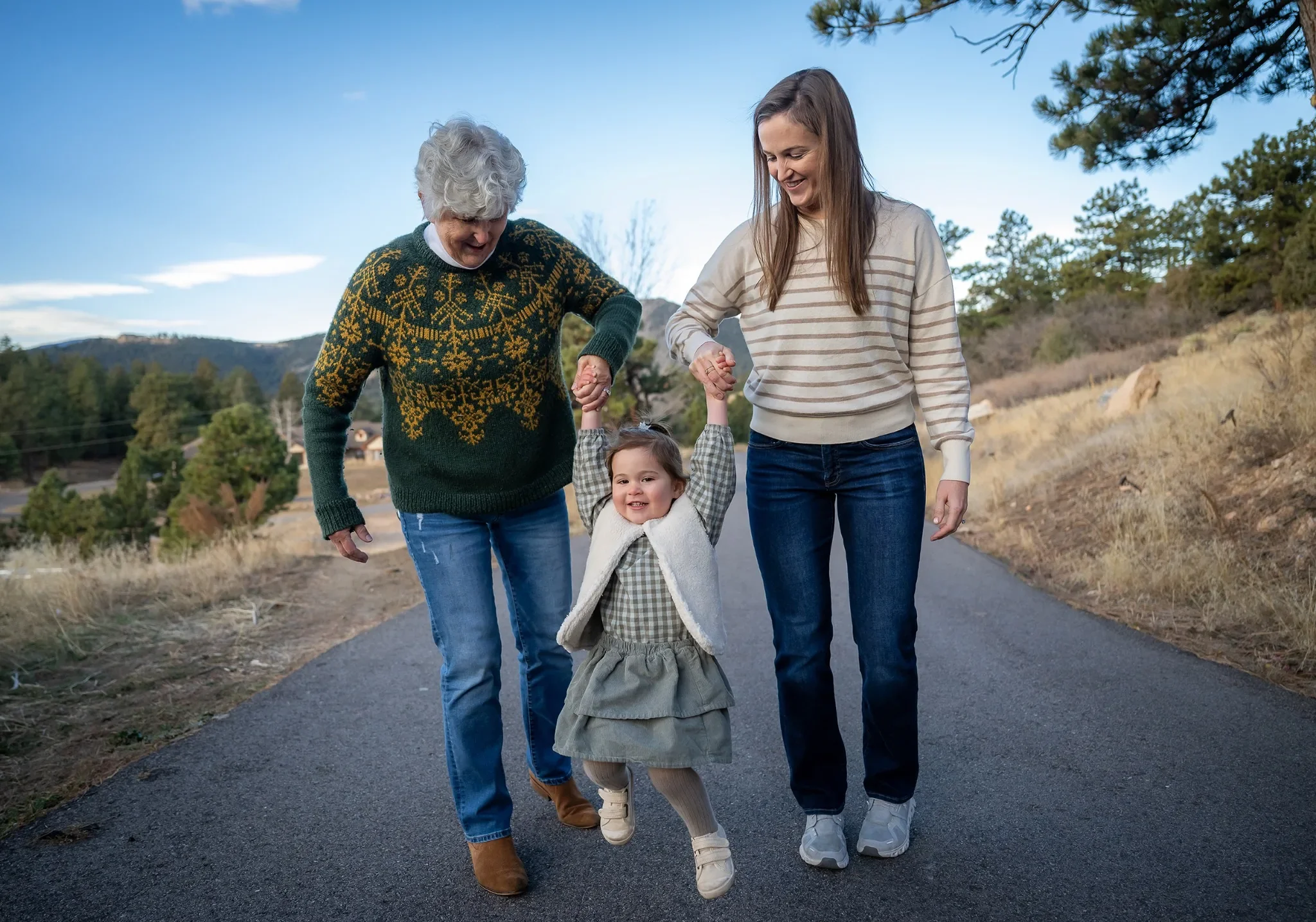 Playful family portrait lifting little girl into the air captured during a family photo session in Indian Hills, Colorado