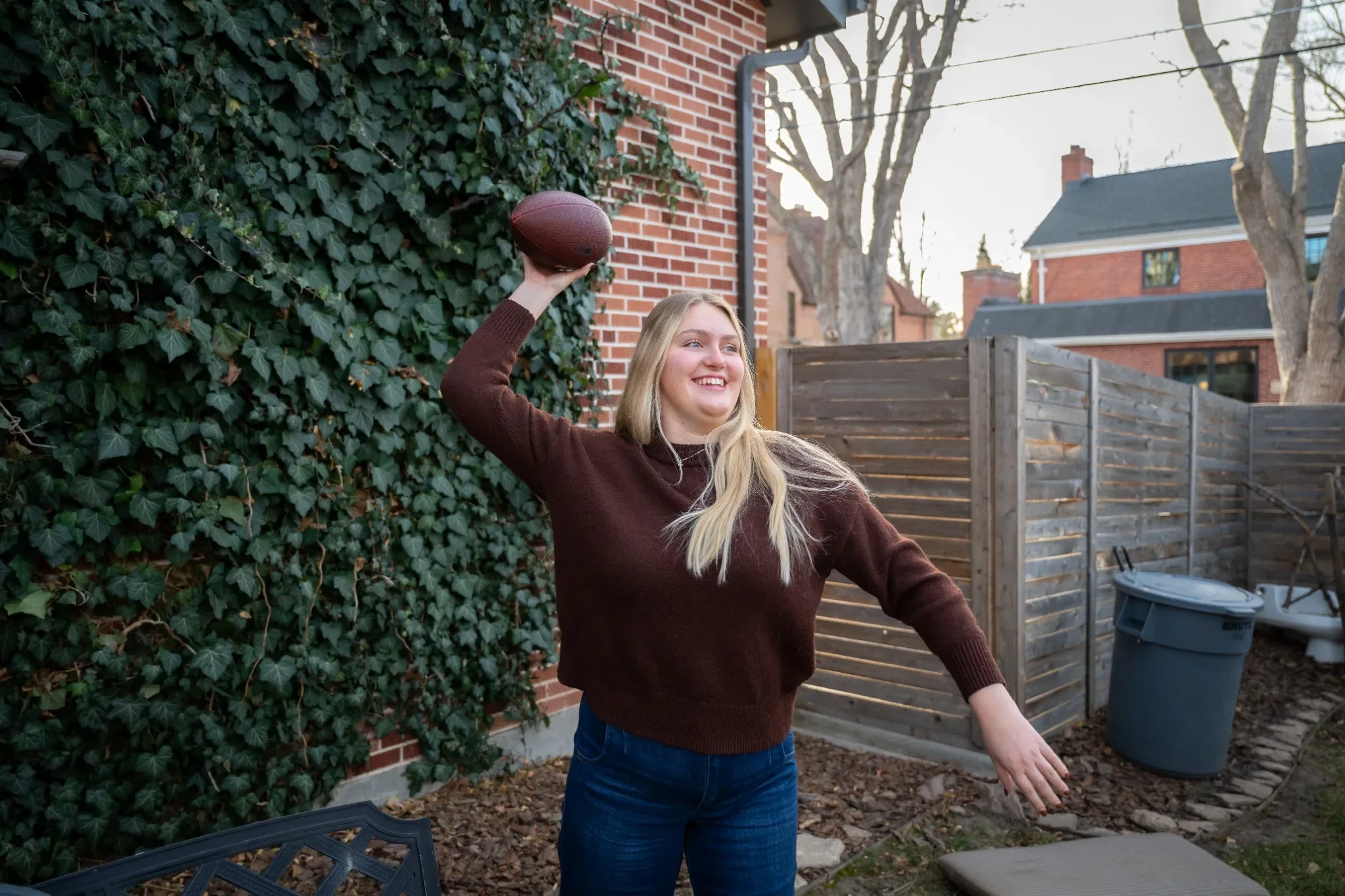 Throwing Football in backyard. Documentary in home family photography in Denver, Colorado.