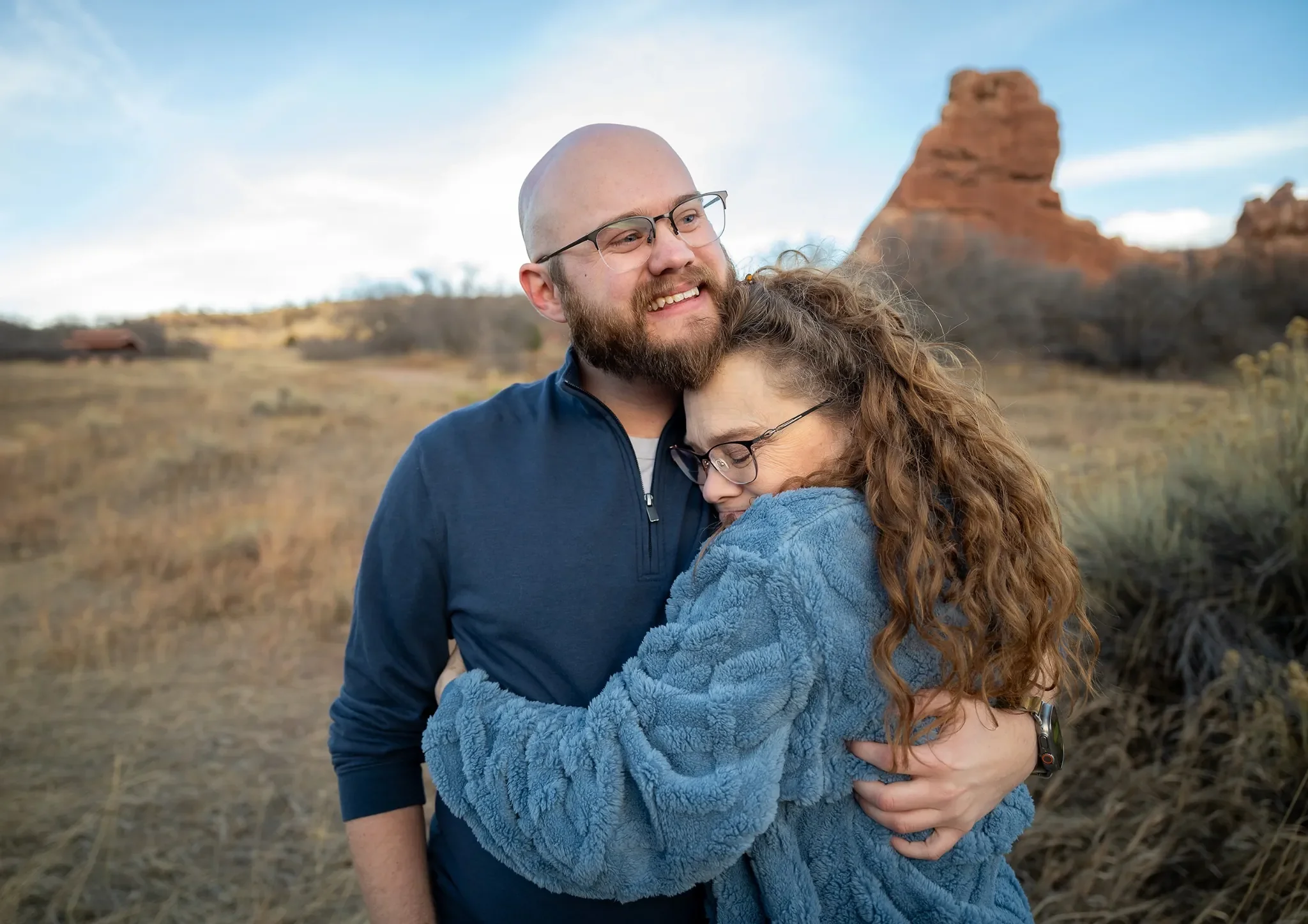 Emotional mom hugs her son after he proposed to his girlfriend during a surprise engagement photo session at South Valley Park in Littleton, Colorado. Ryan Kost Photography.