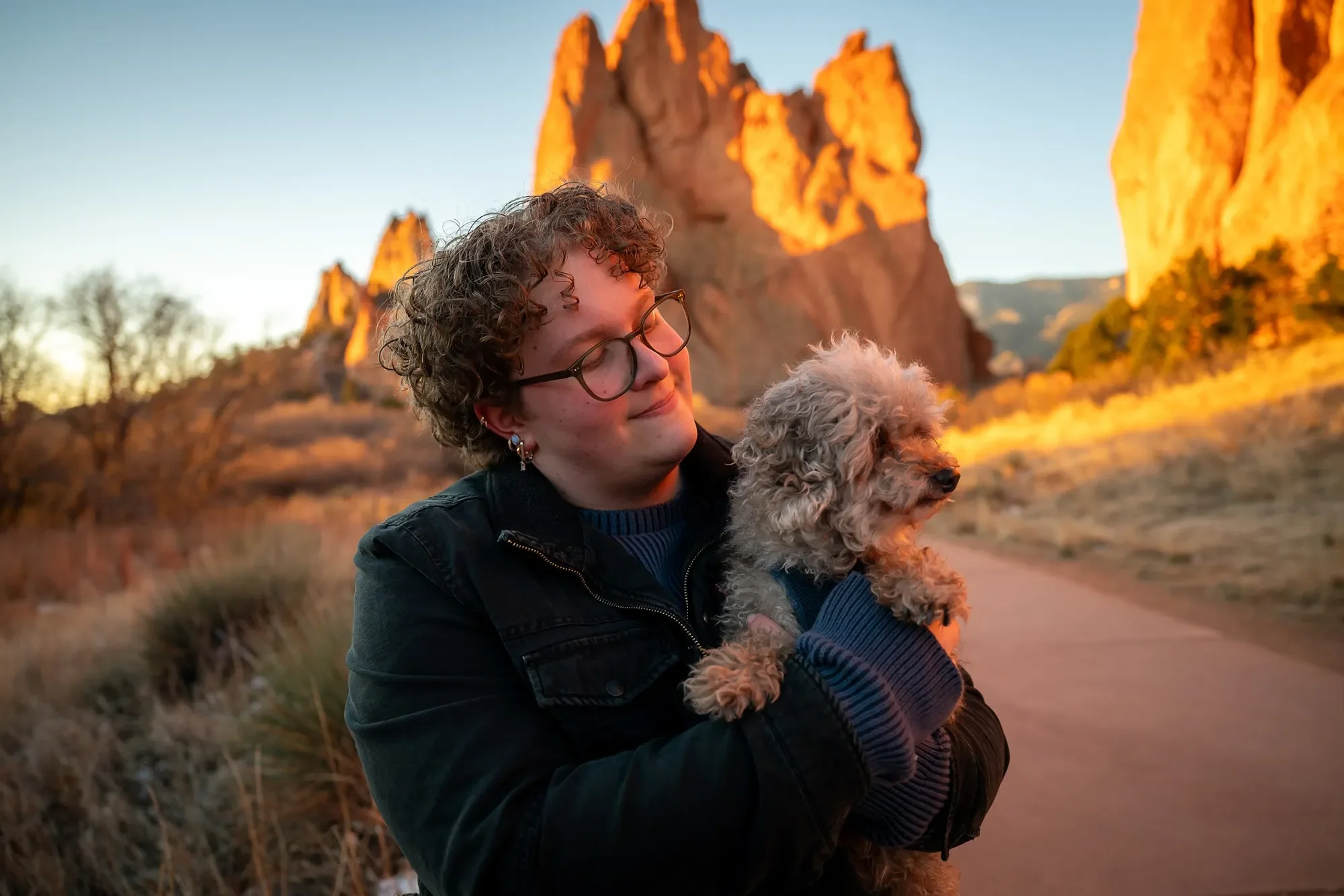 Cute senior portrait with dog during a sunrise photo session at Garden of the Gods in Colorado Springs captured by Ryan Kost Photography.