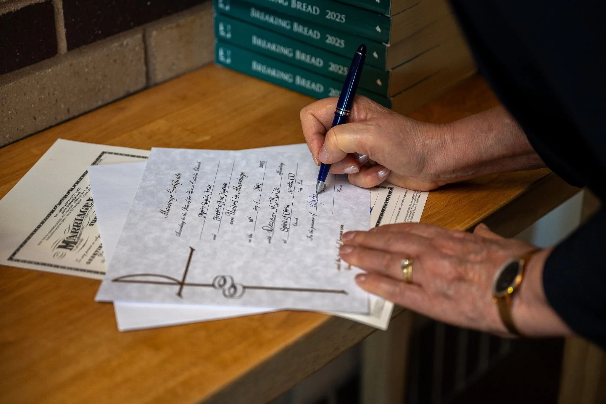 Signing the marraige documents. Timeless elopement moments in Arvada, Colorado—moody chapel light and cinematic emotion captured by Colorado elopement photographer Ryan Kost.