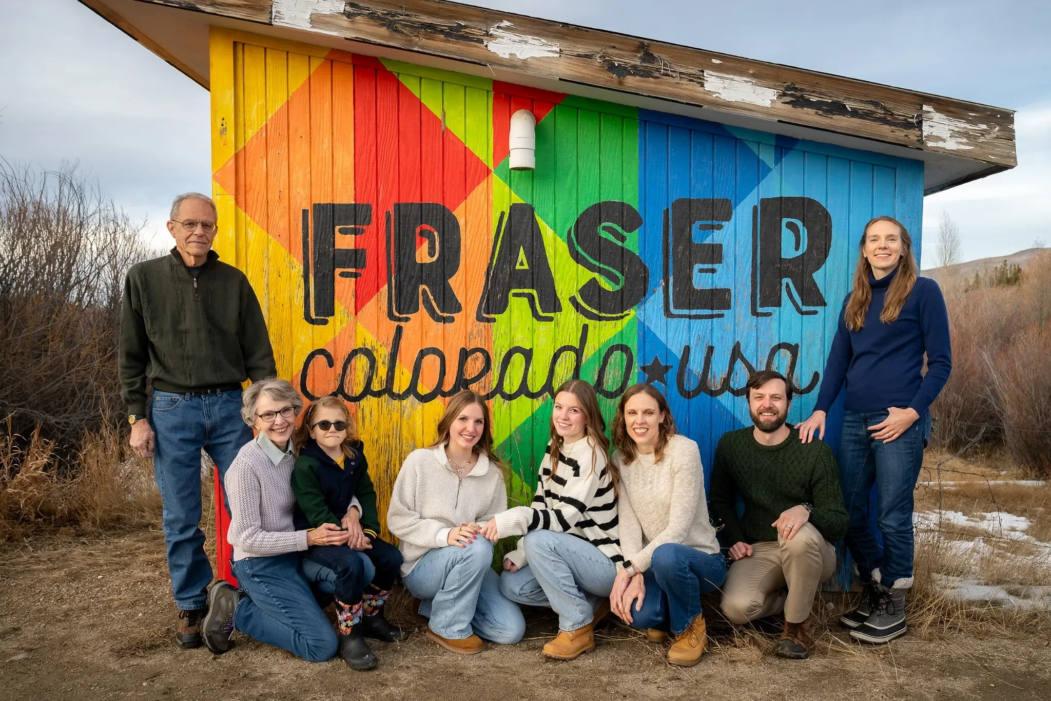 Extended family posing in front of the Fraser, Colorado sign during a winter family photo session